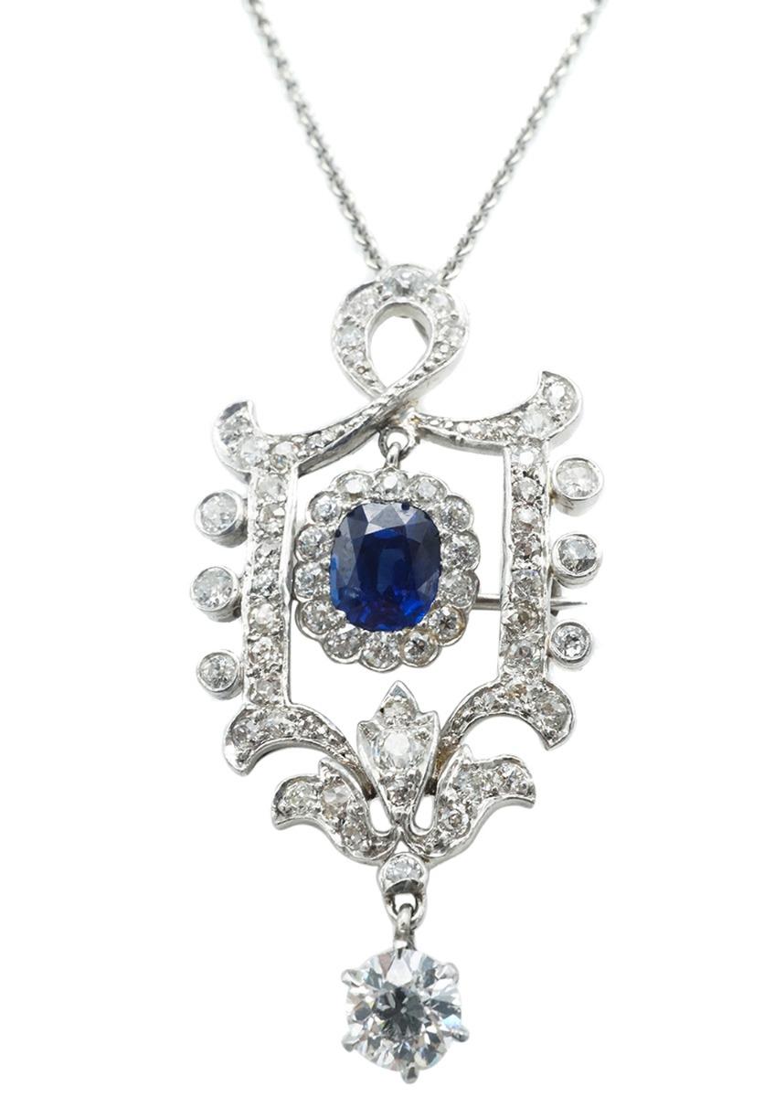 Crafted in platinum featuring a very fine rectangular cushion cut sapphire and an old european cut diamond surrounded by old european cuts, swiss cuts and single cuts.  The chain is 14 karat white gold 16