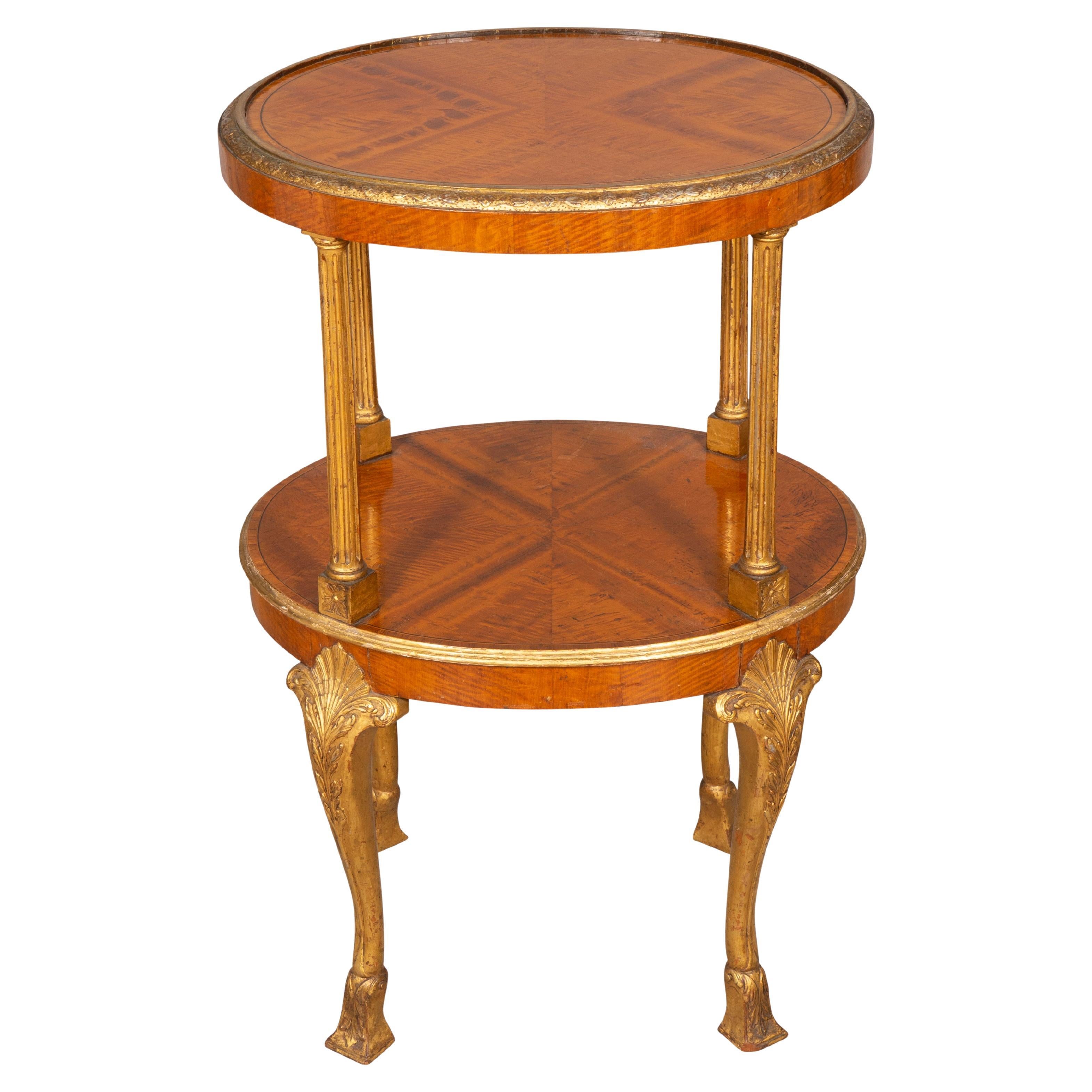 The finest quality. Oval top with quarter veneers and with crossbanded detailed carved edge over a conforming shelf divided by columns and raised on well carved cabriole legs joining shell carved knees ending on square feet. The underside with an