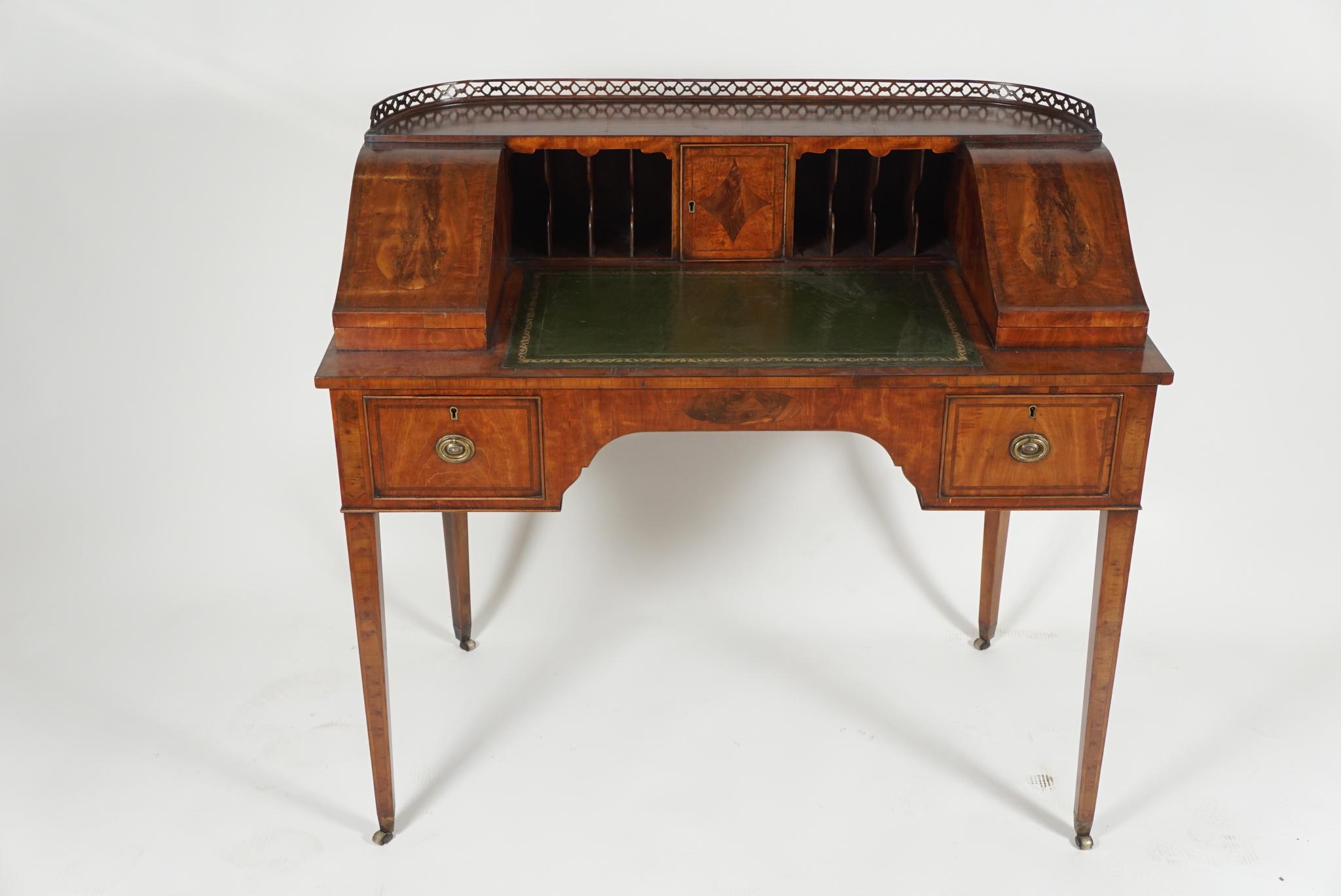 Beautiful small desk from Edwardian period, English, in satinwood with tooled leather writing surface and brass fitments and tapered legs. 
The upper portion has slots for envelopes and two small boxes for storing stationery, etc. Design based on