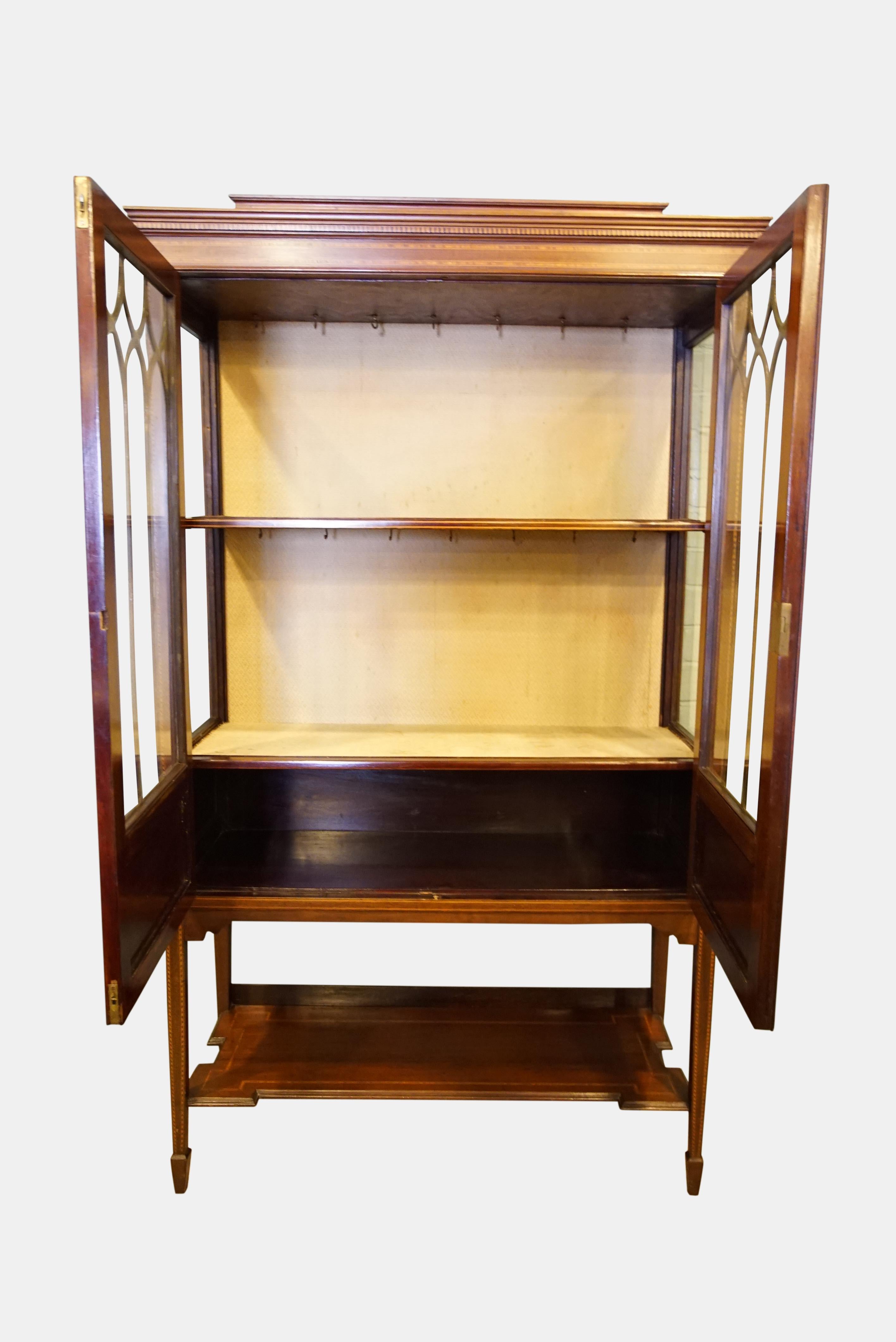 An Edwardian satinwood banded, inlaid display cabinet with two-doors on square tapering legs and spade feet,

circa 1900.