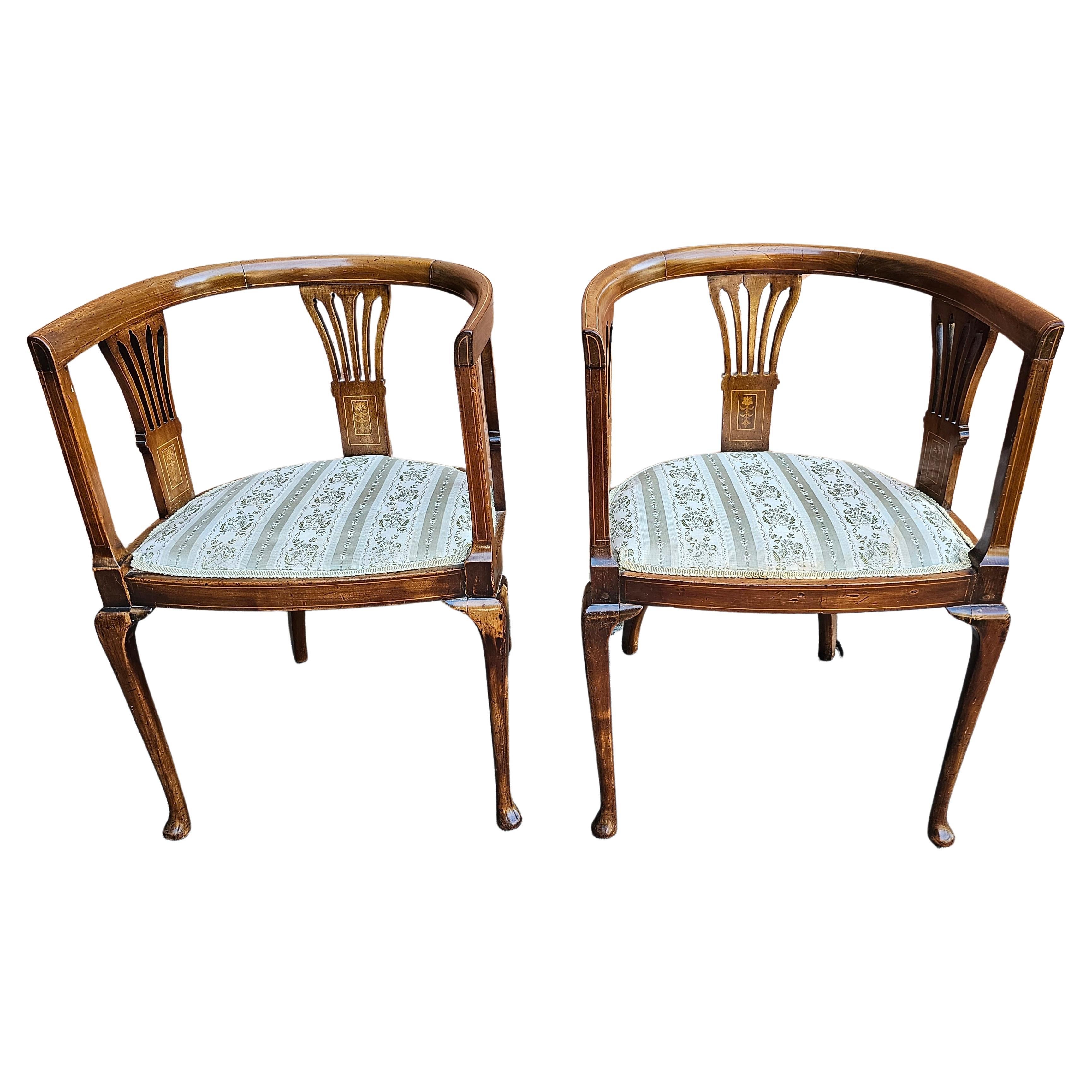 Paire de fauteuils club d'époque édouardienne en acajou incrusté de bois de satin et à dossier en tonneau, tapissés. en vente