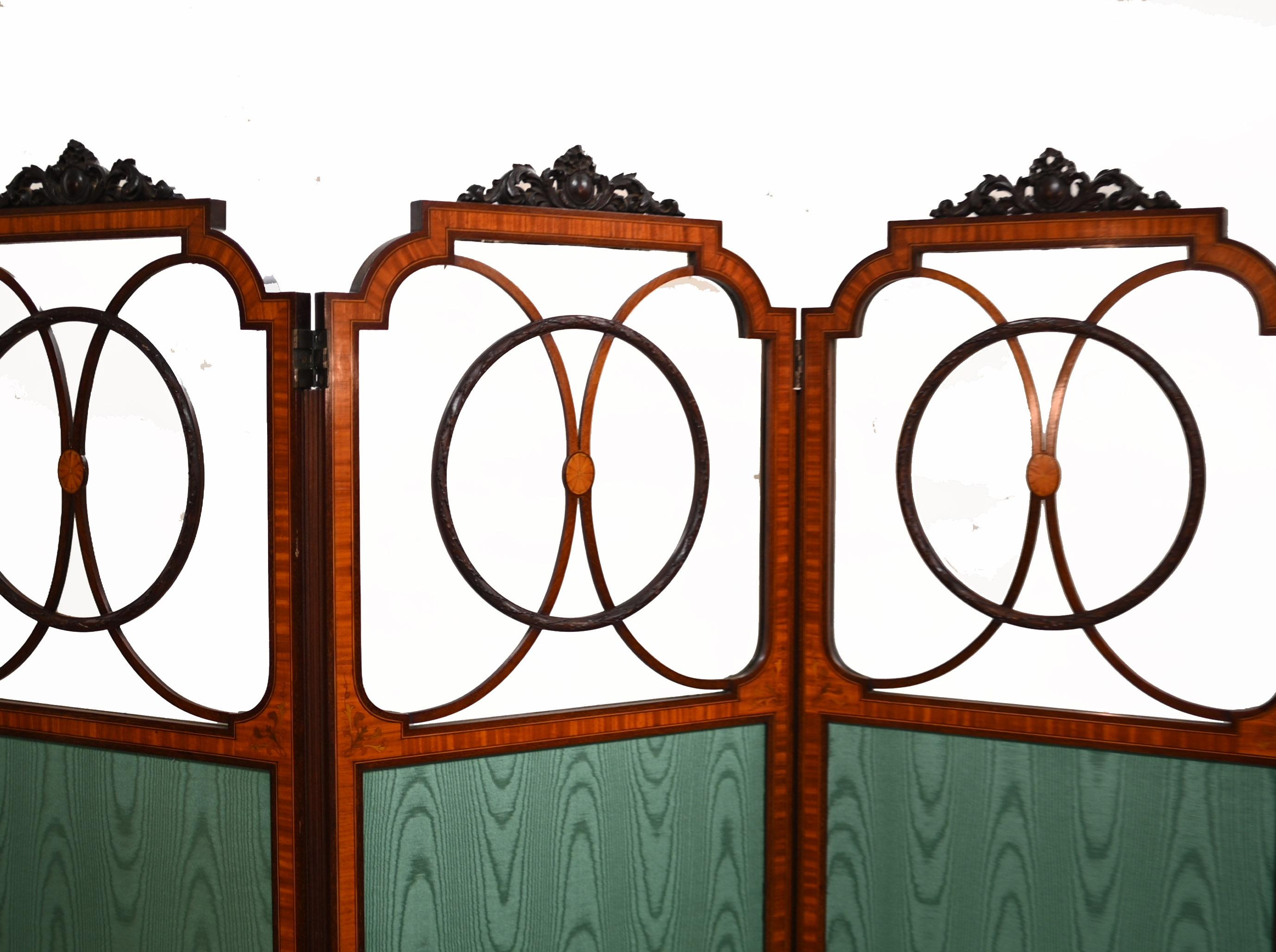 Stand out antique Edwardian four panel screen or room divider
Such a refined piece, cool and understated design
Surmounted with finely carved motifs crossbanded in satinwood and inlaid with marquetry
Main panels lined with green satin
We date