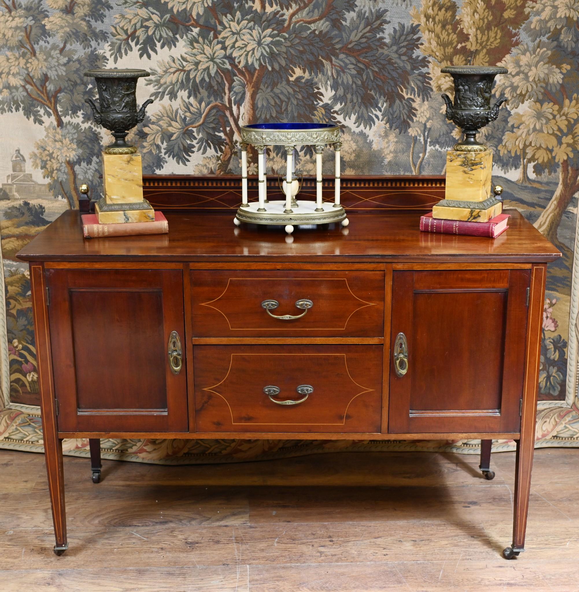 Edwardian small side board with string inlays circa 1910
Hand crafted from mahogany with Sheraton manner motifs in the inlay
Two drawers and two side cabinets so ample storage
Clean and stylish piece with tapered legs
Viewings available by