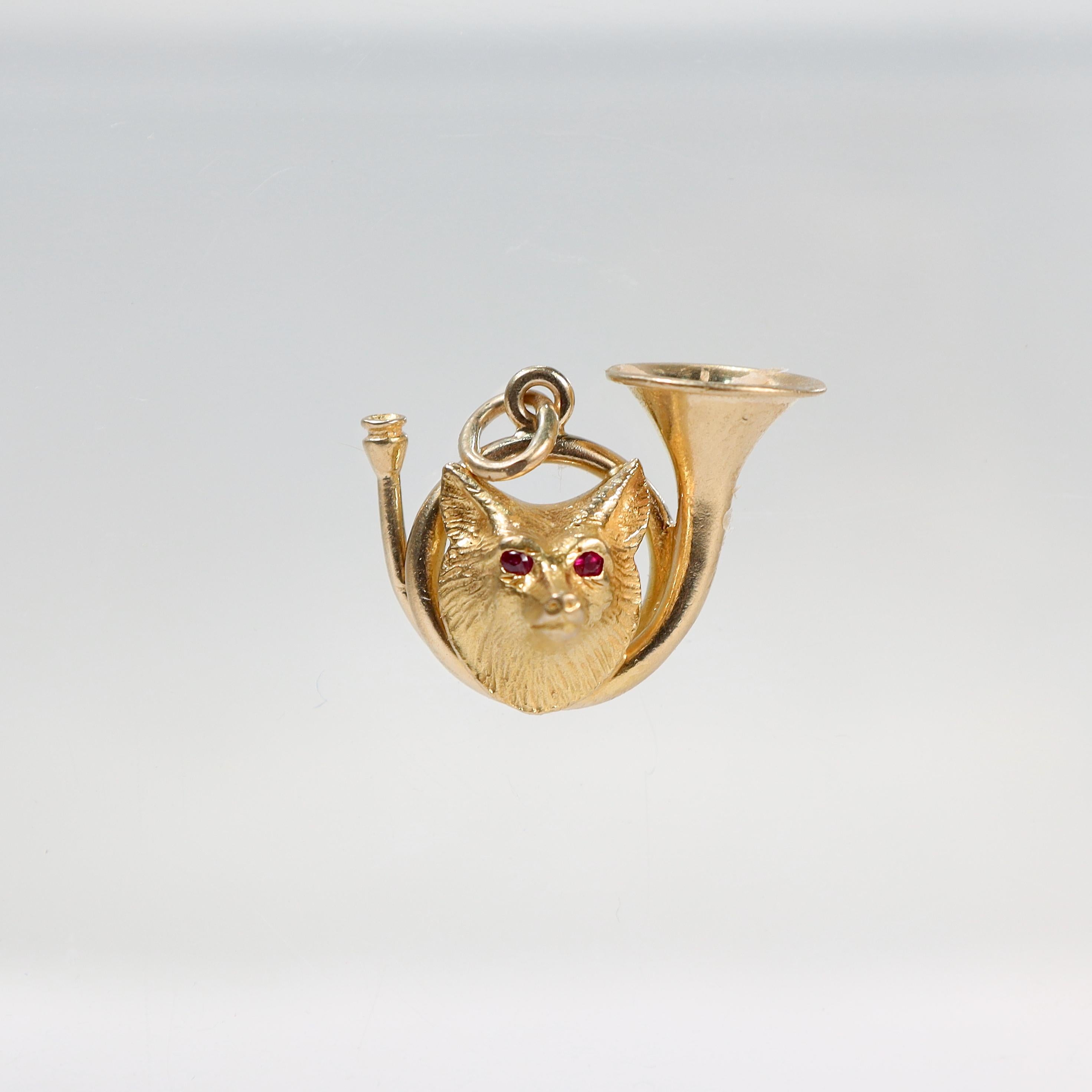 A very fine signed Edwardian fox hunt charm.

In 14 karat yellow gold. 

By Whiteside & Blank.

Comprised of a fox head mounted on gold trumpet that is with flush-set tiny round ruby eyes.

With an attached bale to easily add chain or attach to a