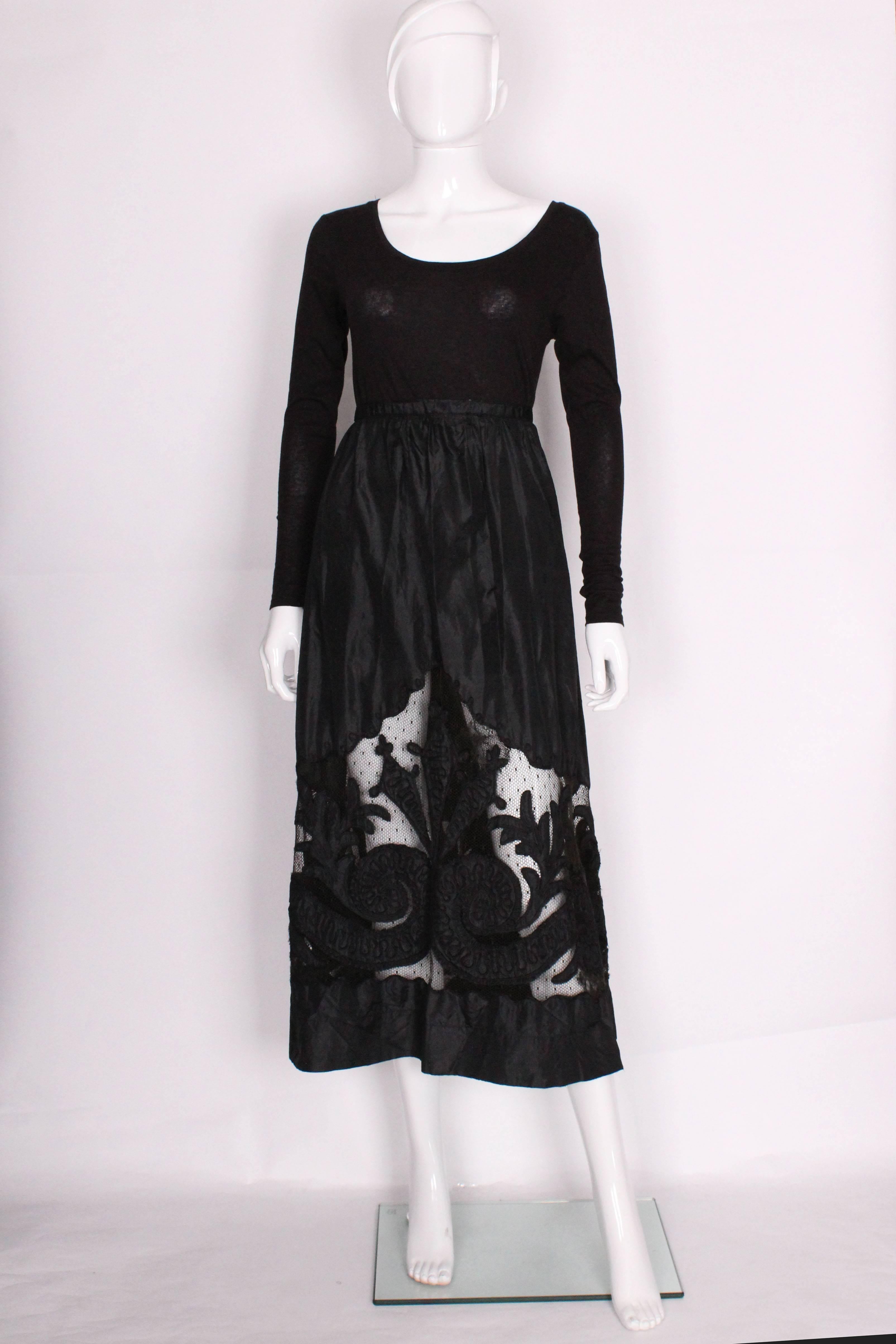 This is a really beautiful, black skirt from the Edwardian era. It's made of a heavy silk that has a slight shine to it and has a large cut out panel at the bottom that is filled in with netting. On top of the netting there are decorative panels of