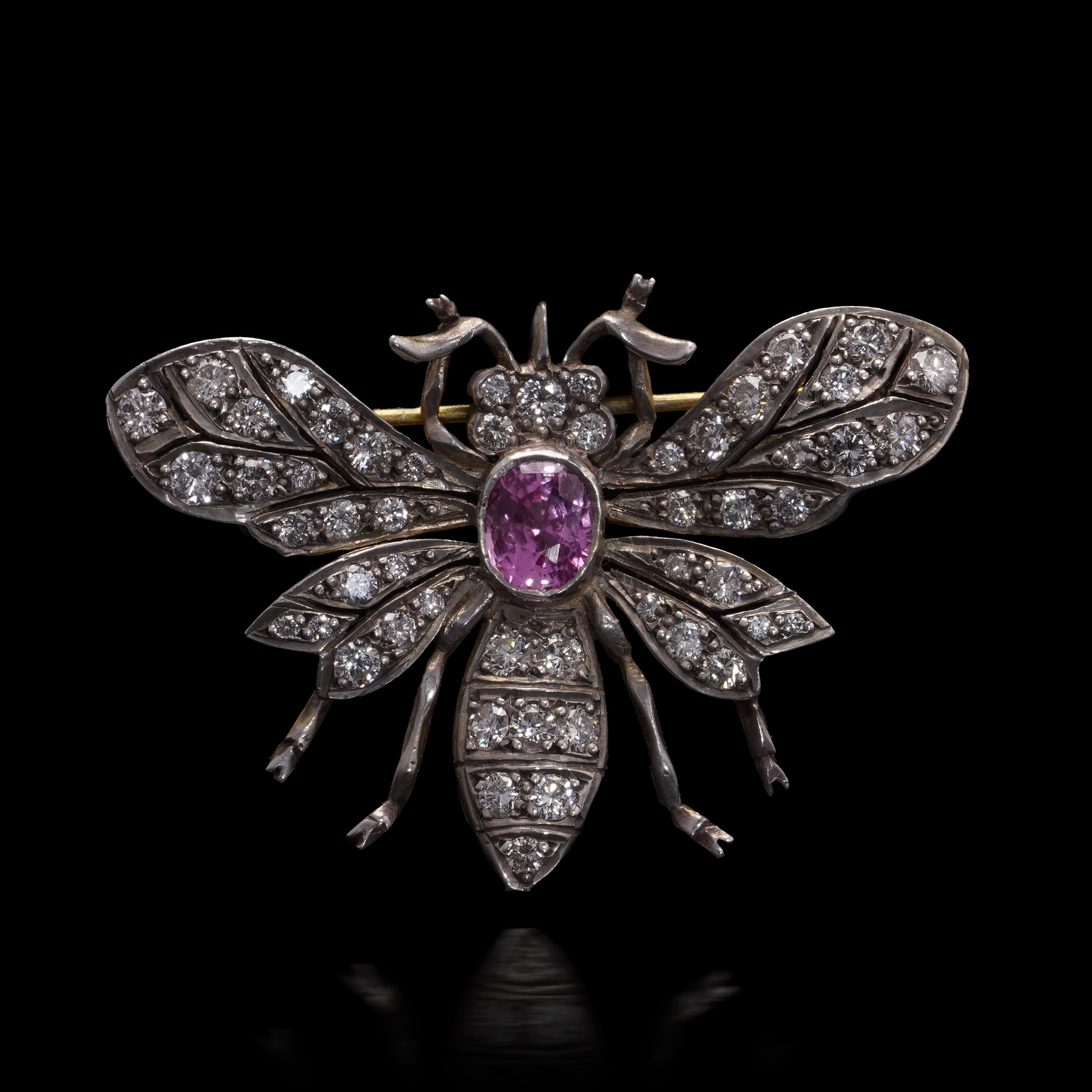 The body of the brooch is intricately modelled with openwork wings and a highly detailed form, pavé-set with 53 round brilliant-cut diamonds, estimated total weight approximately 1.10 carats, of VS2–SI1 clarity and G–H colour. At the centre sits a