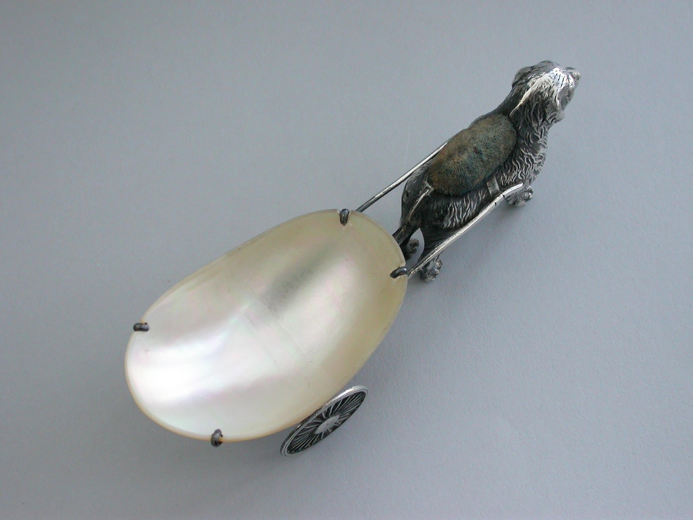 An extremely rare Edwardian novelty silver pin cushion, modelled as a dog (possibly a Newfoundland) pulling a mother of pearl cart on two wheels. The dog realistically modelled with fine detail and complete with original velvet cushion.

By Adie &
