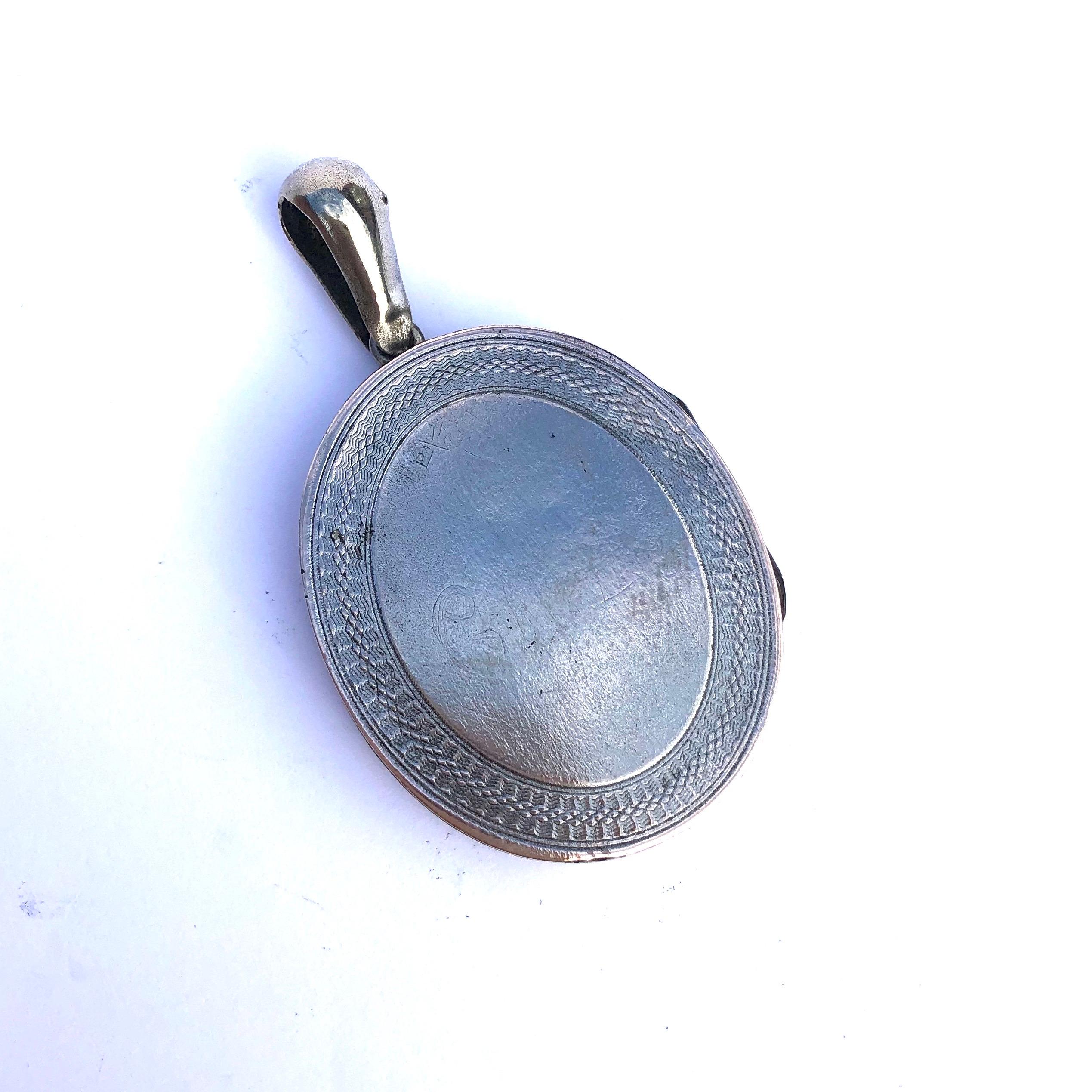 This rather modern looking locket features engraved detail and silver layers. The engraving includes leaves, lines and wonderful texture. One of the sides inside the locket has a complete compartment. 

Dimensions Inc Loop: 56x 33mm

Weight: 14.7g