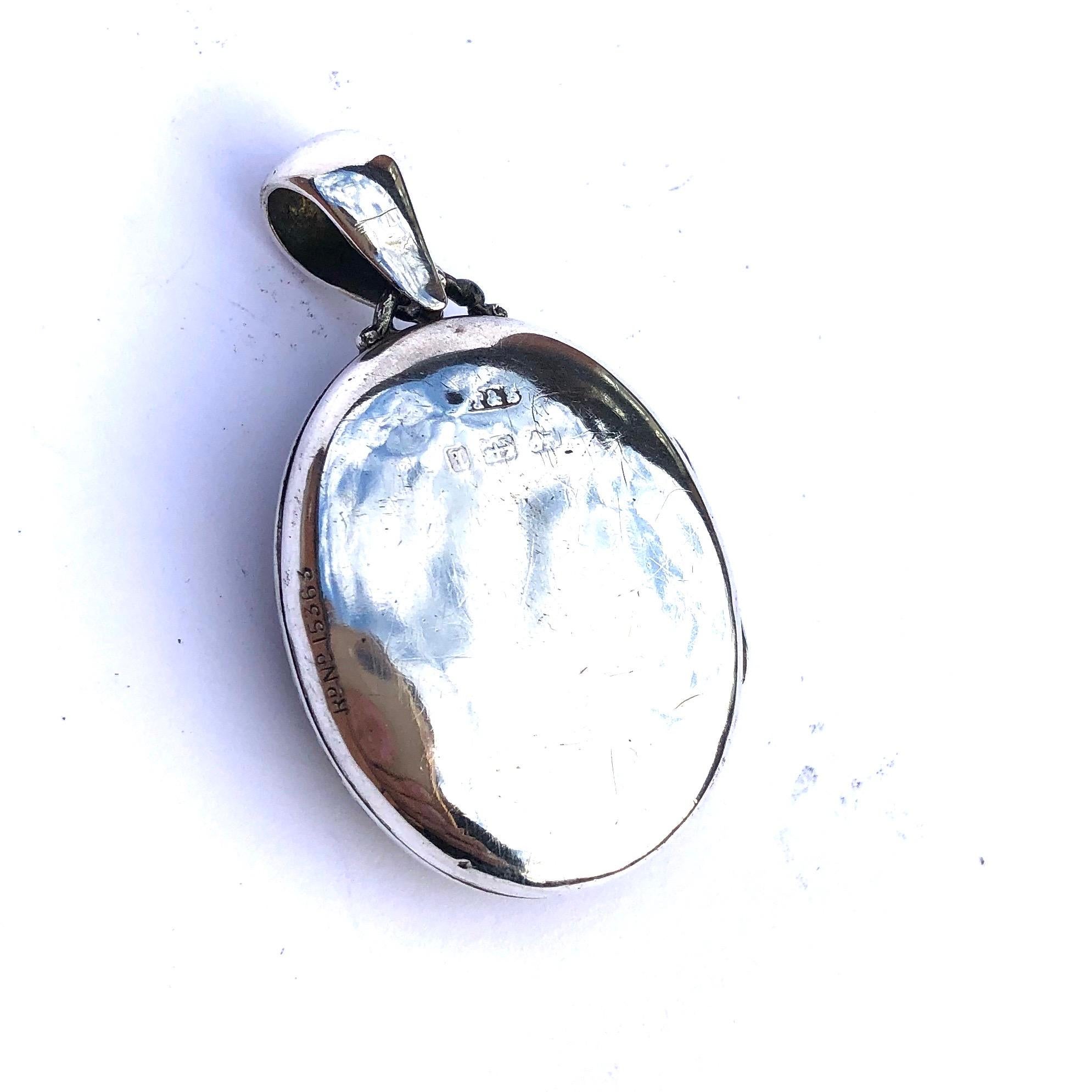 The front of this locket is packed with detail! The multi levels of the silver and the darker silver tones making those details stand out even more. On the inside of this locket there is an original panel with a lock of hair sat behind it. Made in