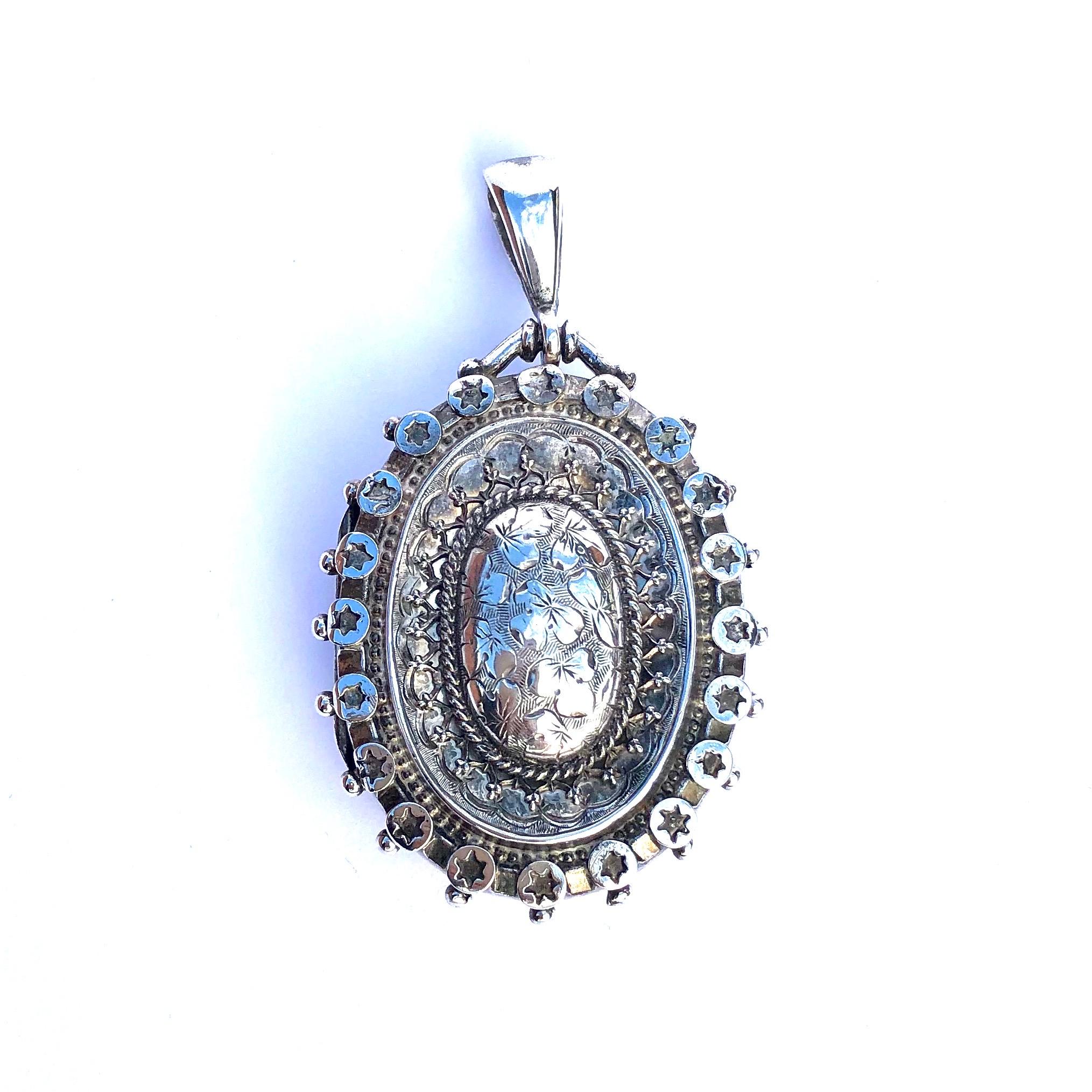 This locket couldn't have any more detail! There is beautiful star moulded frame with beaded edges, rope twist detail and proud panel with flower engraving. Inside the locket there are two portraits of smartly dressed women. Made in Birmingham,