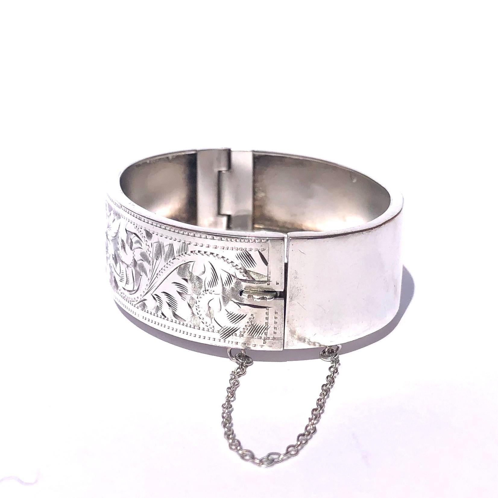 This silver bangle has a delicate feel to it and the engraving is absolutely exquisite. The design of the engraving is made up sweet flowers and leaf detail. 

Inner Diameter: 64mm
Bangle Width: 19mm

Weight: 23.9g