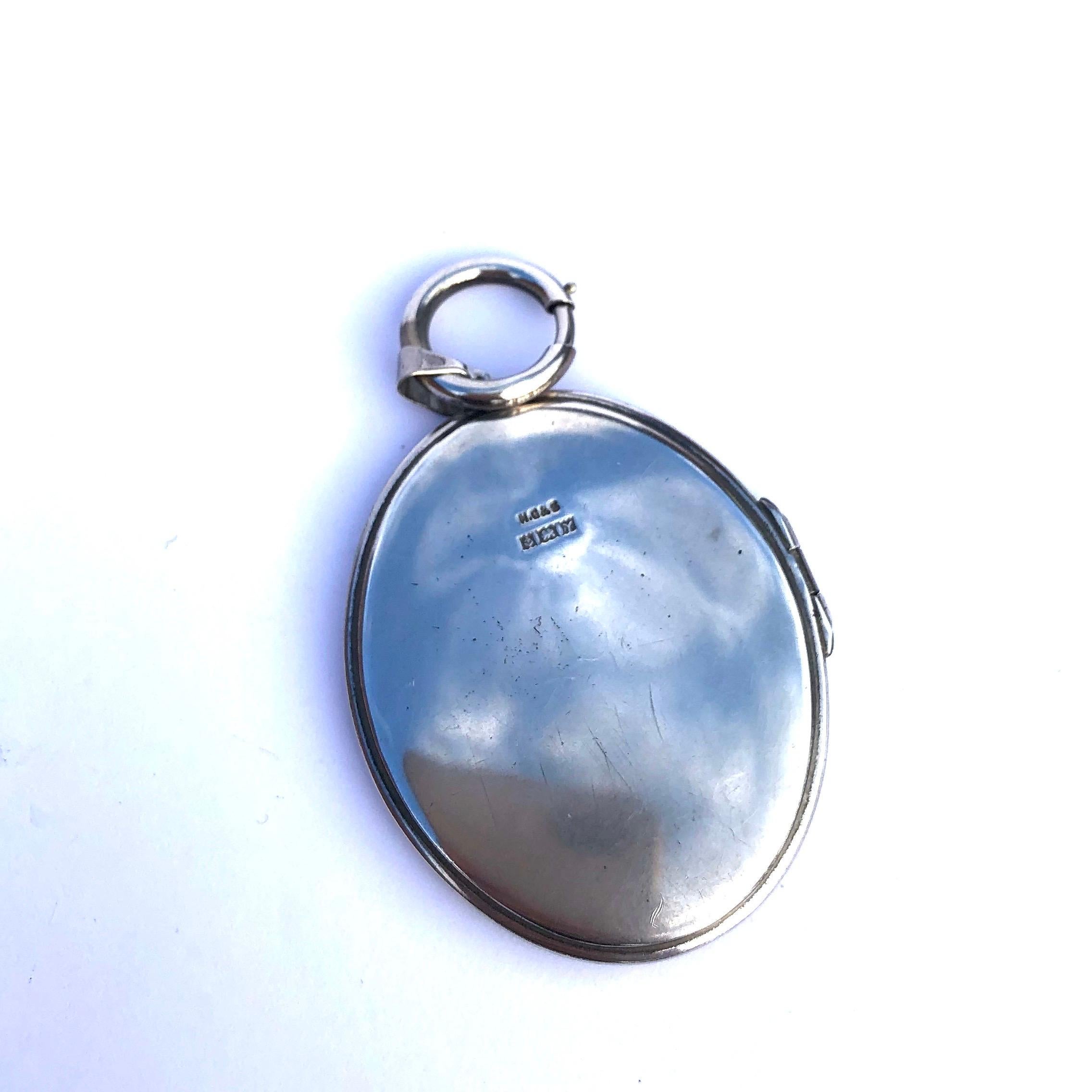 This locket is slim and has a delicate feeling despite it being quite large. The classic engrave is a swirl style with lots of detail. At the top of the locket there is a large chunky bolt clip, which makes the locket feel modern and stylish. Made