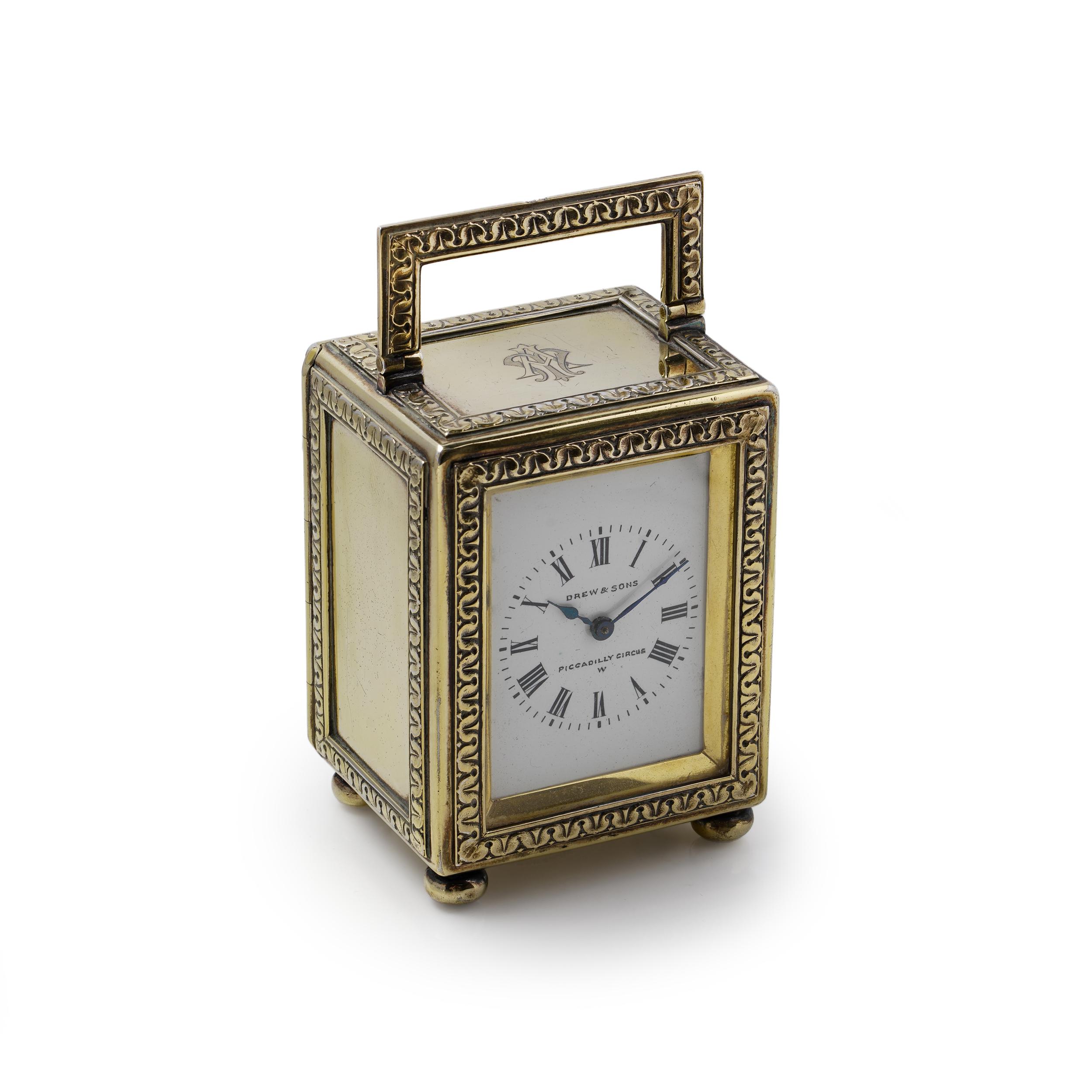 A fine Edwardian silver-gilt miniature carriage clock crafted by Drew & Sons, Piccadilly Circus, London. Hallmarked for London, 1913, this charming clock is elegantly designed with a decorative gilt silver frame featuring embossed classical foliate