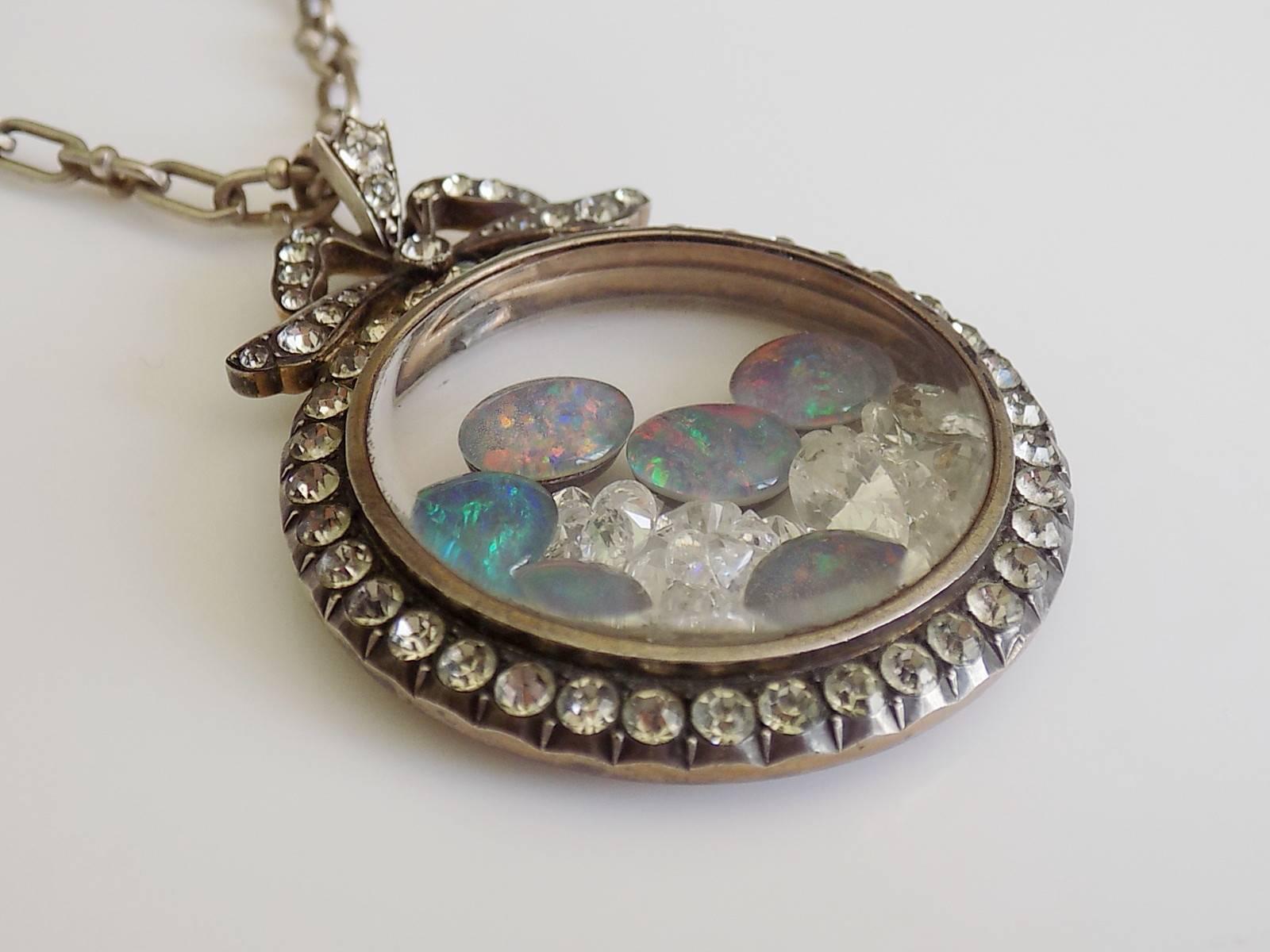 A Large Edwardian Silver Gilt and paste locket pendant filled with a triplet black Opals and clear crystals on fancy Sterling Silver chain. English origin.
Drop of the locket 56mm, width 40mm.
Length of the chain 18 1/4