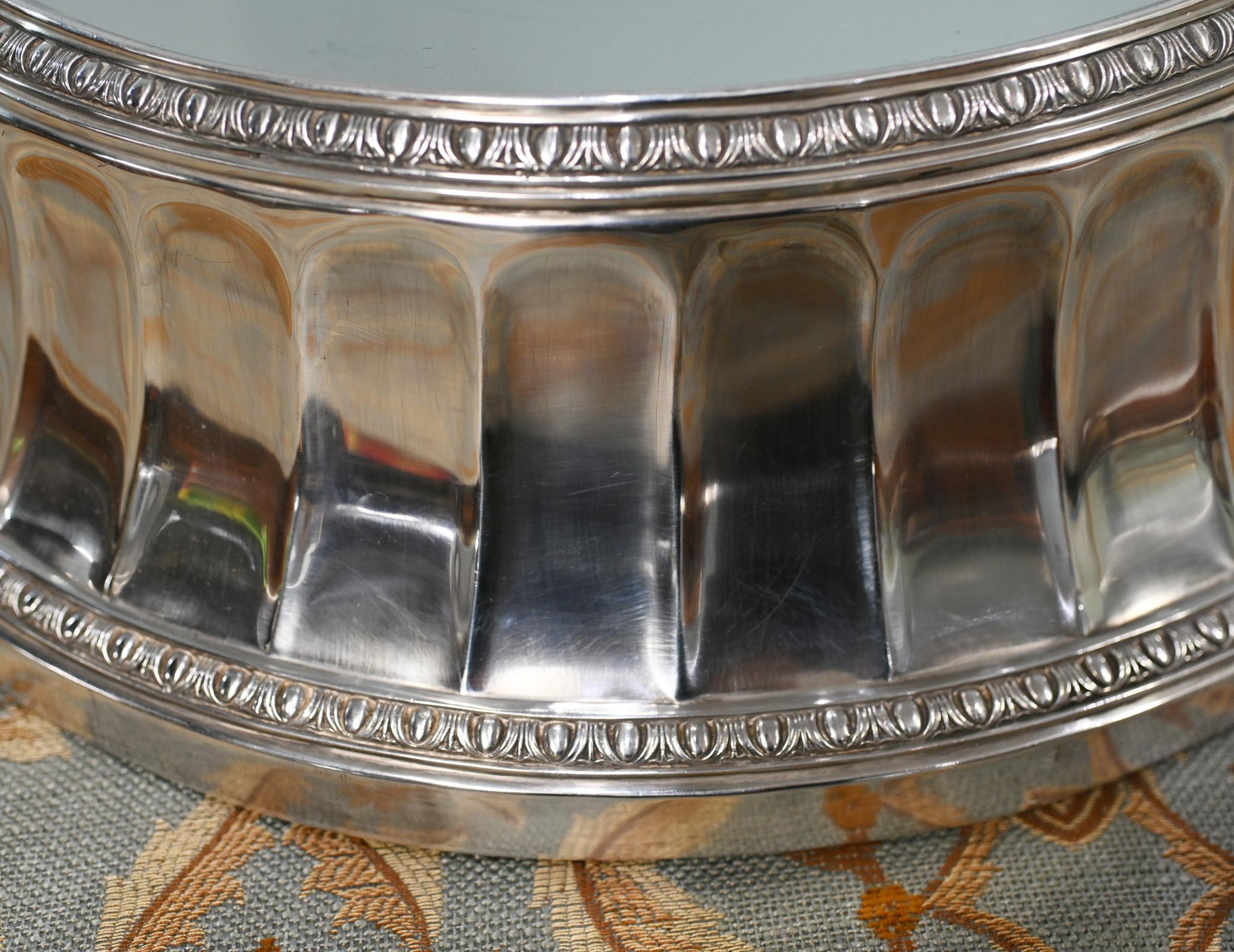 Un beau plateau circulaire en métal argenté, idéal pour présenter des centres de table, des gâteaux ou des objets décoratifs.
Circa 1910
La pièce présente un plateau en miroir à l'intérieur d'un bord moulé surélevé, ce qui lui confère une surface