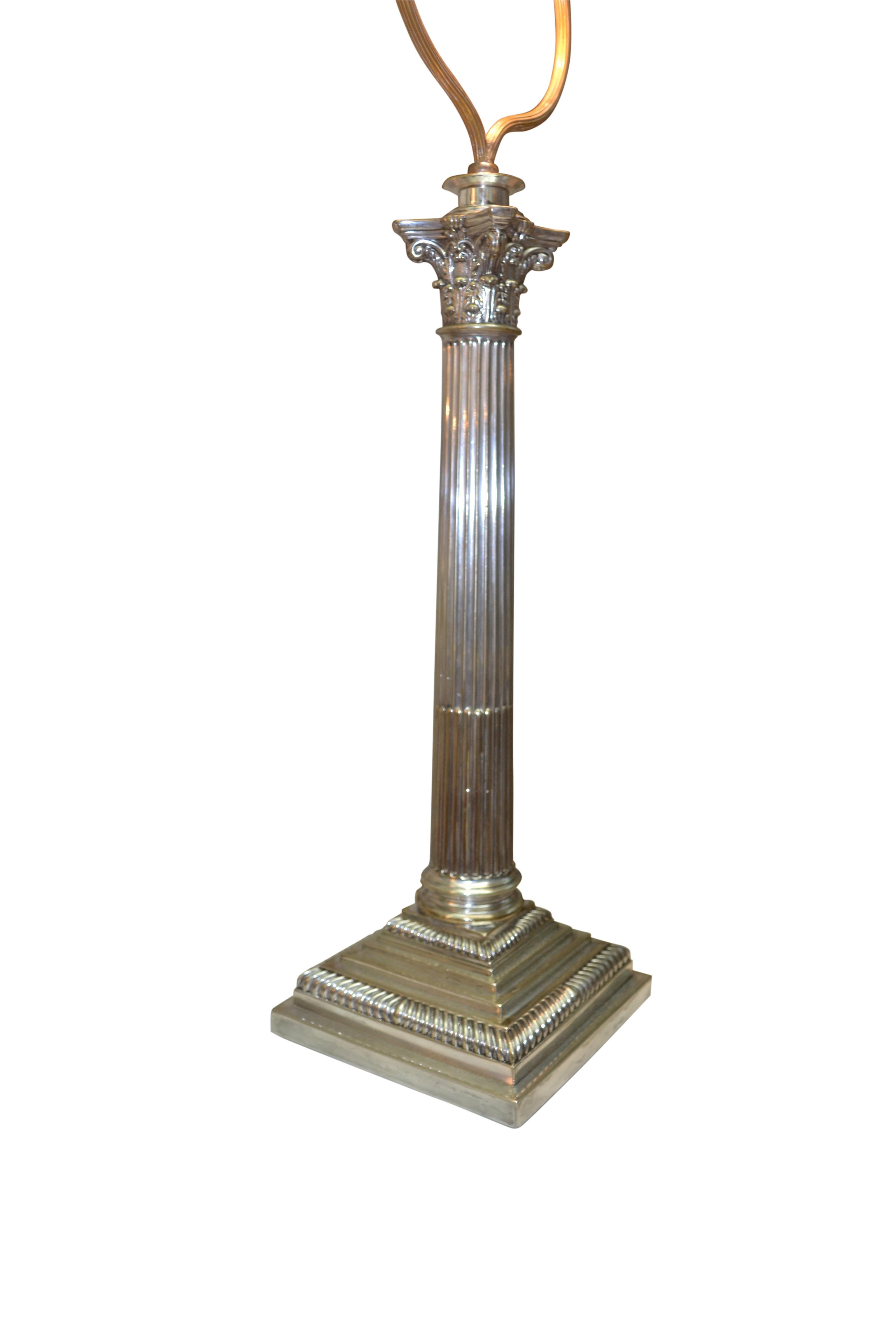 A neoclassical Edwardian English fluted column lamp capped by a Corinthian capital and set on a stepped square base.