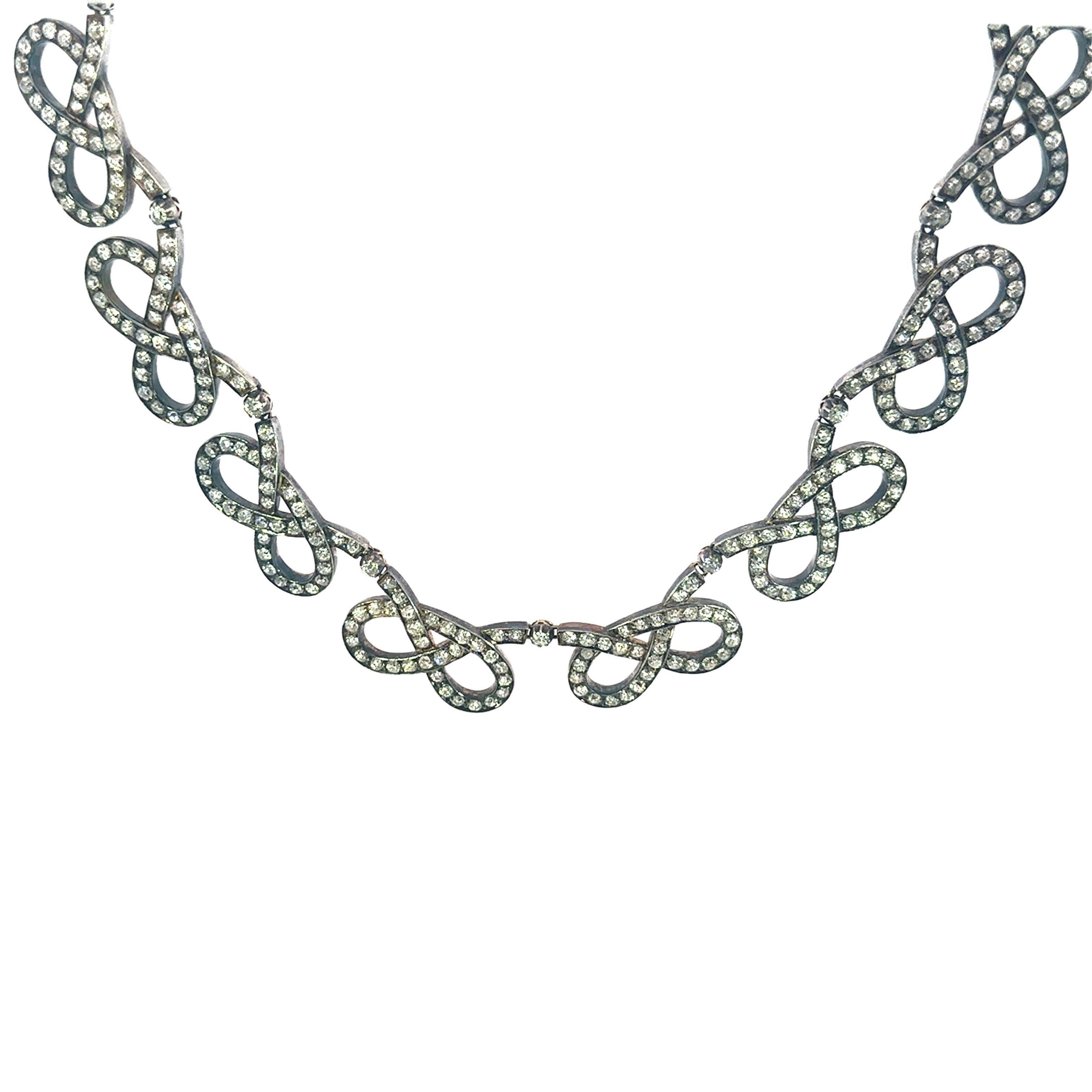Edwardian Silver Topped Gold Infinity Bowtie Diamond Necklace ~31.9ctw Old Miners

This exceptional Edwardian link necklace, crafted circa 1900, is not only a stunning example of fine jewelry but also a tangible piece of history. Over a century old,