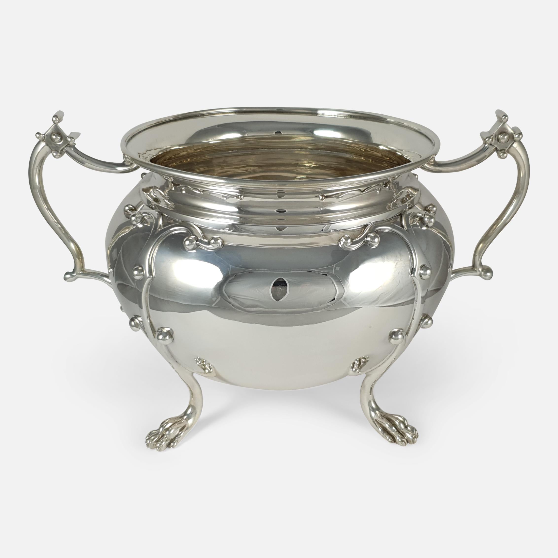 An antique Edwardian sterling silver twin-handled jardinière bowl by James Wakely & Frank Clarke Wheeler, London, 1905. The bowl is of circular rounded form, fitted with two handles, and sitting on four paw feet.

Assay: - .925 (Sterling
