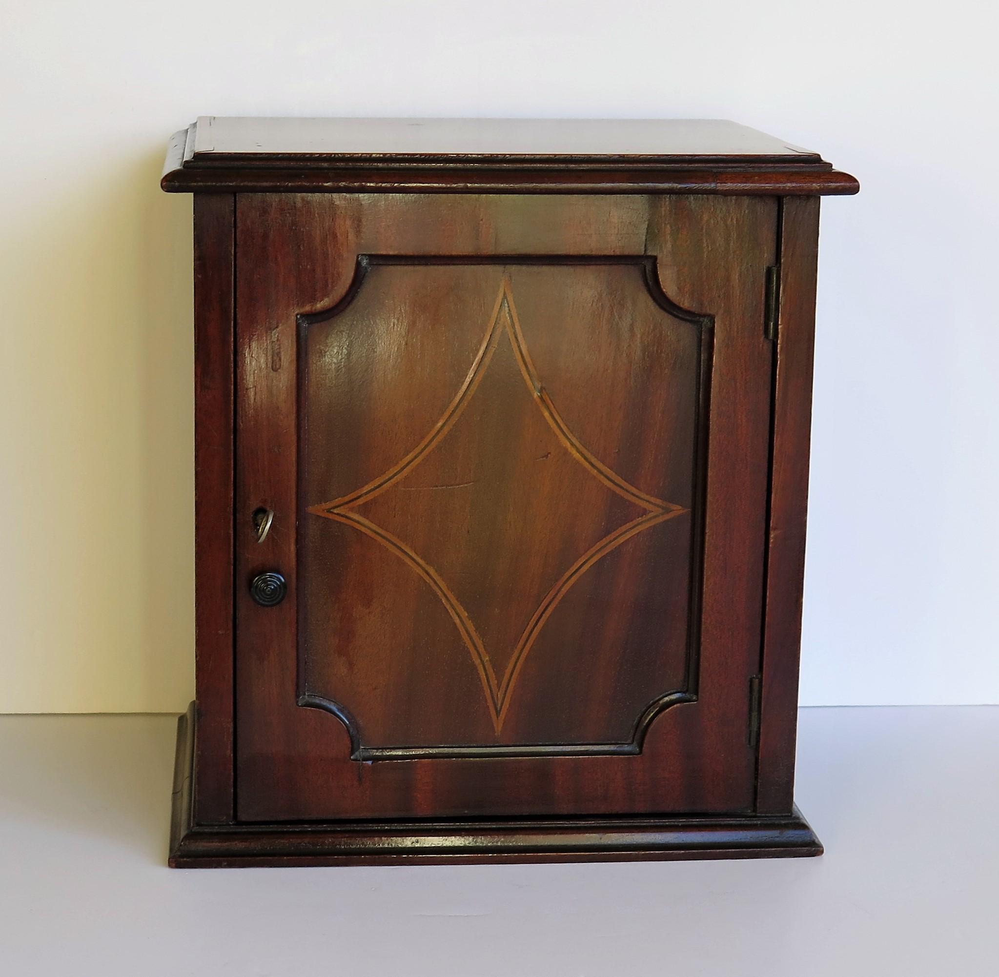 This is a very good quality English Edwardian period, table or desk cabinet or box with fine inlaid and crossbanded detail, having a hinged door with working lock and key, dating to the turn of the 19th century Edwardian period, circa 1905.

The