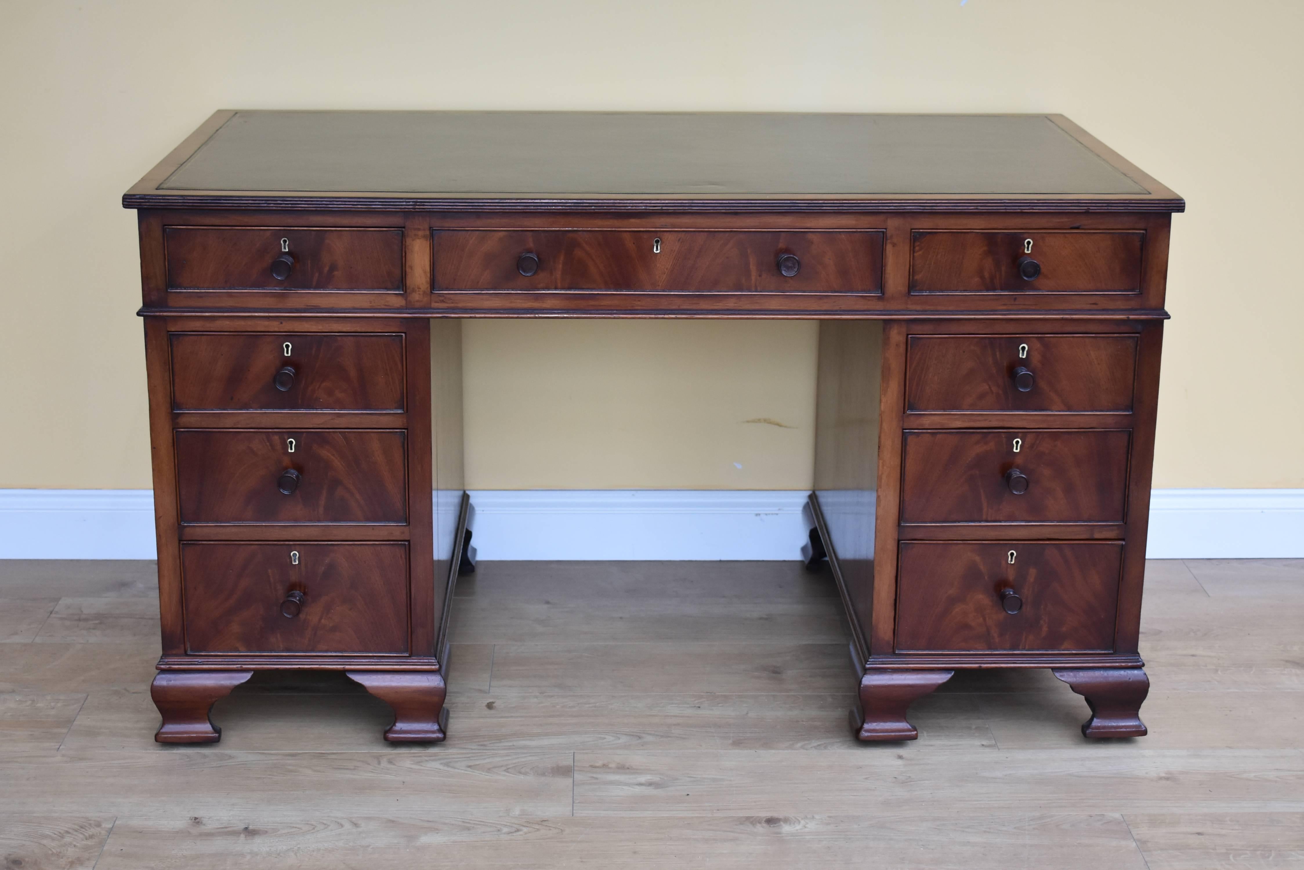For sale is a good quality Edwardian mahogany pedestal desk. The top of the desk has a black writing surface, with gold line tooling, above three drawers in the top. The top fits onto two pedestals, each with brass escutcheons and turned handles,