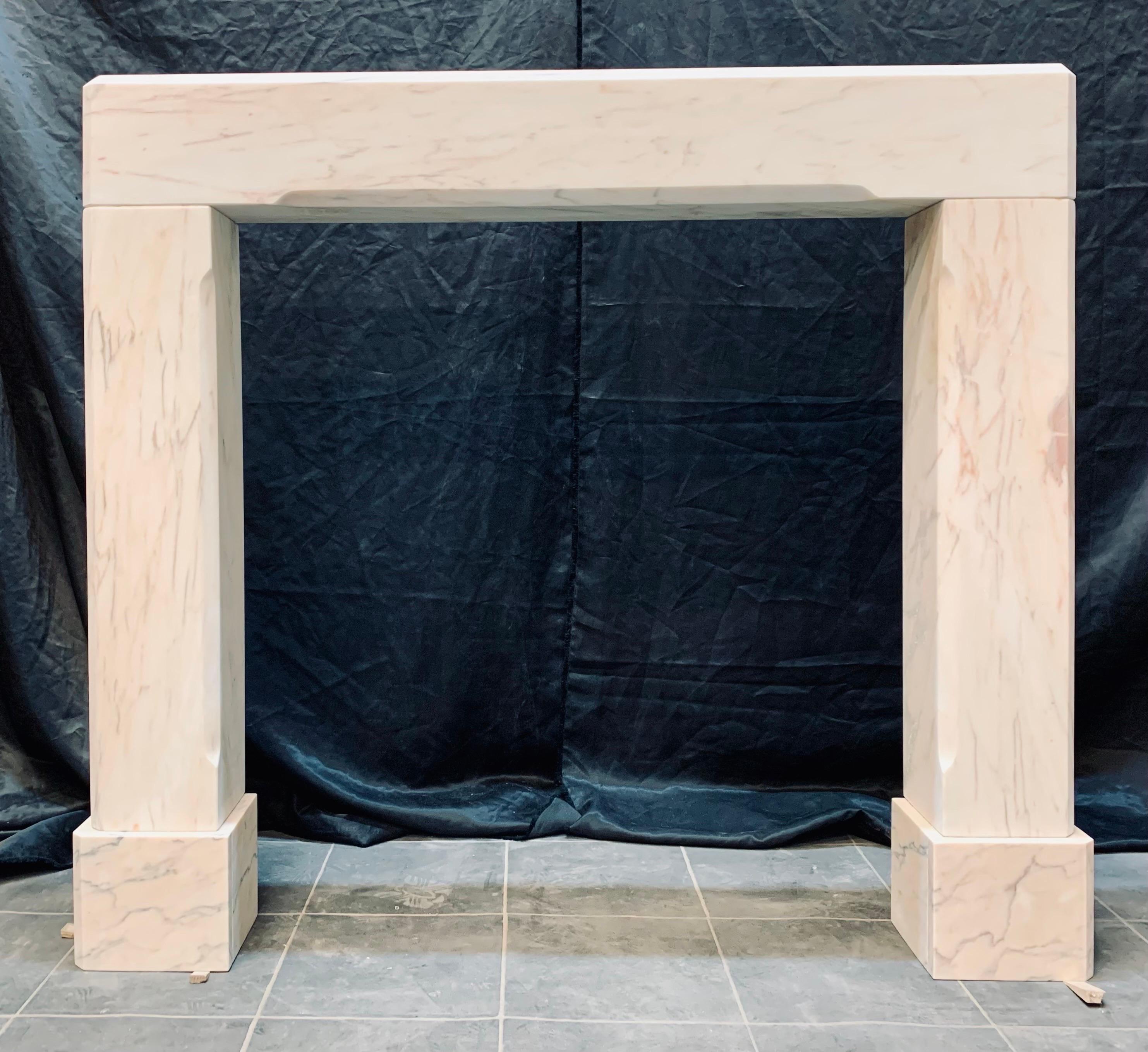 An unadorned Edwardian solid marble fireplace surround. A solid top beam with chamfer edges, the solid section jambs have further chamfers and rest on marble foot blocks. 

English 1910

Fire opening size: 850mm high x 802mm wide.

Overall