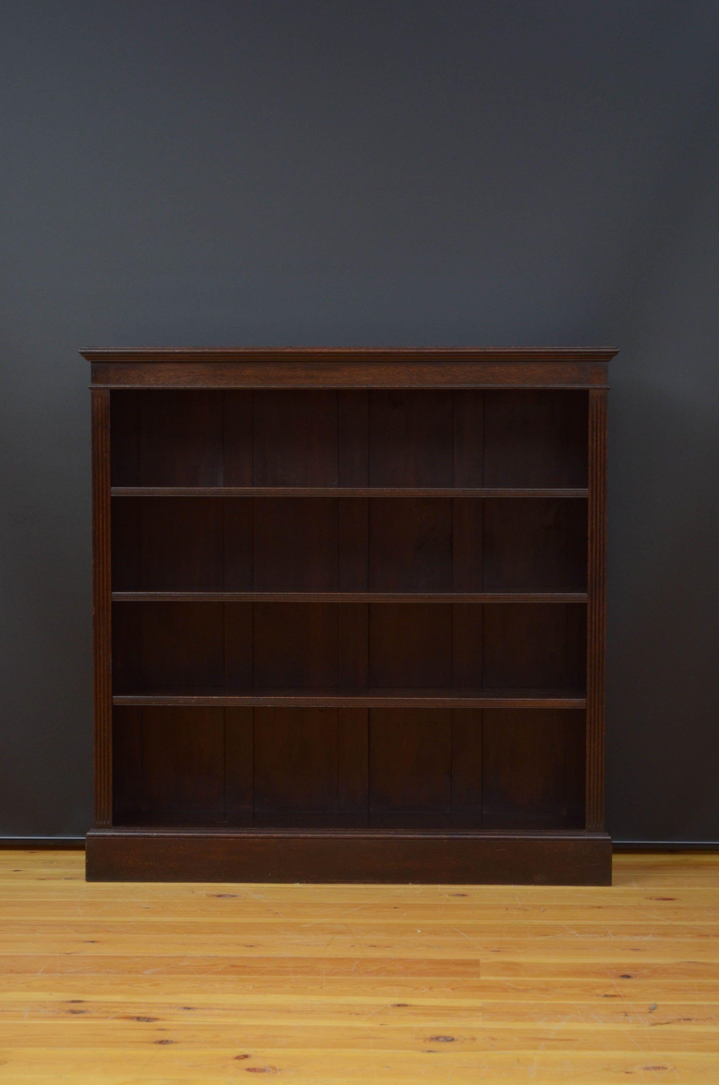 Sn5225 Edwardian open bookcase in oak with moulded top, shallow frieze and three height adjustable shelves flanked by reeded pilasters, standing on moulded plinth base. This antique bookcase retains its original dark finish and patina, all in home