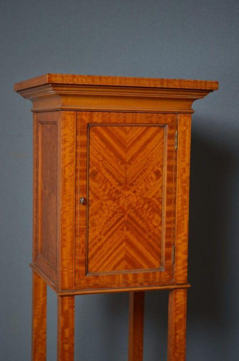 Sn706 Unusual, satinwood stand, having boxwood and ebony string inlay to top, the small cupboard section which has a single shelf to the interior is panelled to all sides, and stands on tapering outswept legs with shaped undertier, has original lock