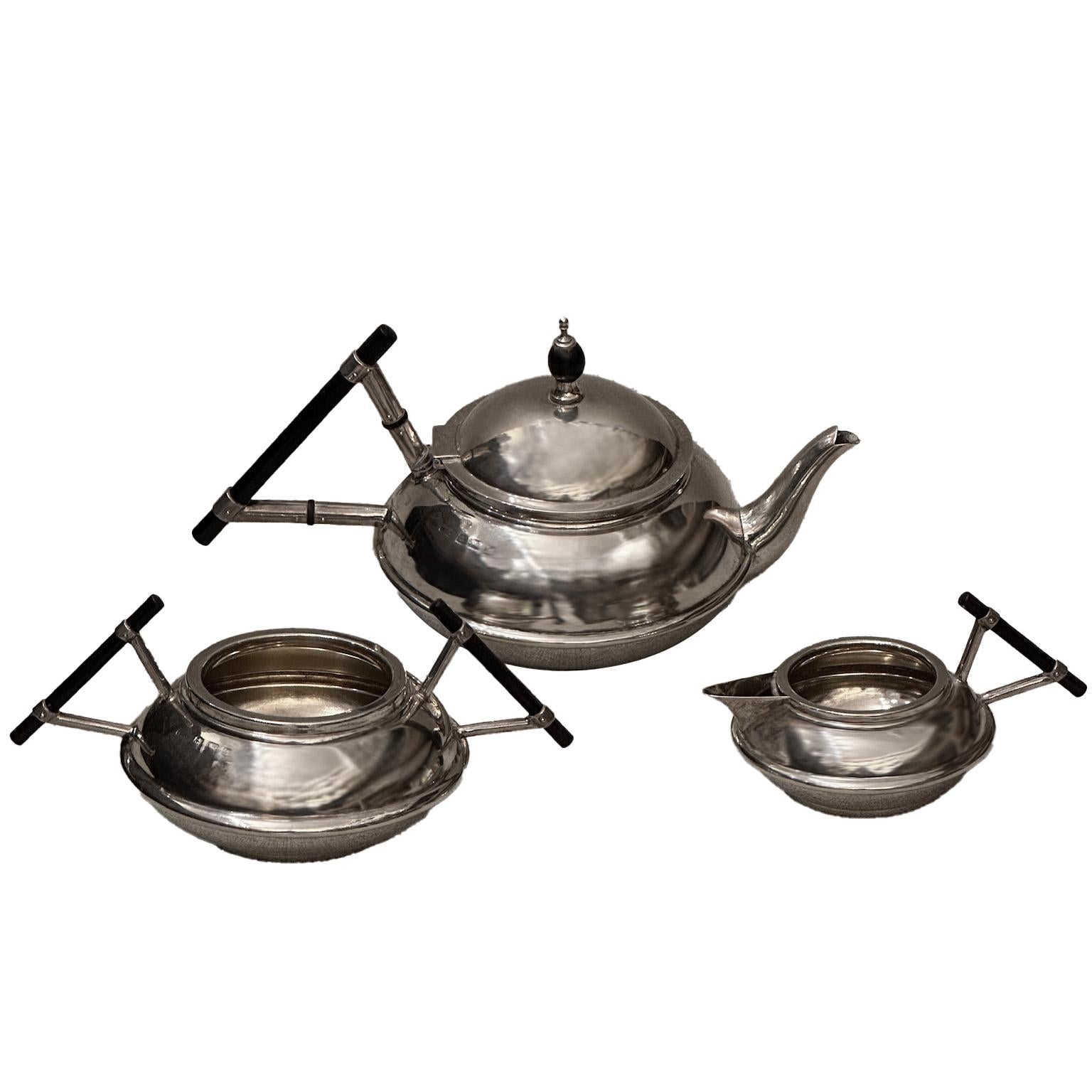 Descubre este exquisito juego de té de tres piezas de plata de ley, con tetera, azucarero y lechera, de la época eduardiana, hacia 1907. Cada pieza muestra un diseño refinado y atemporal, muy inspirado en Christopher Dresser, con una buscada forma