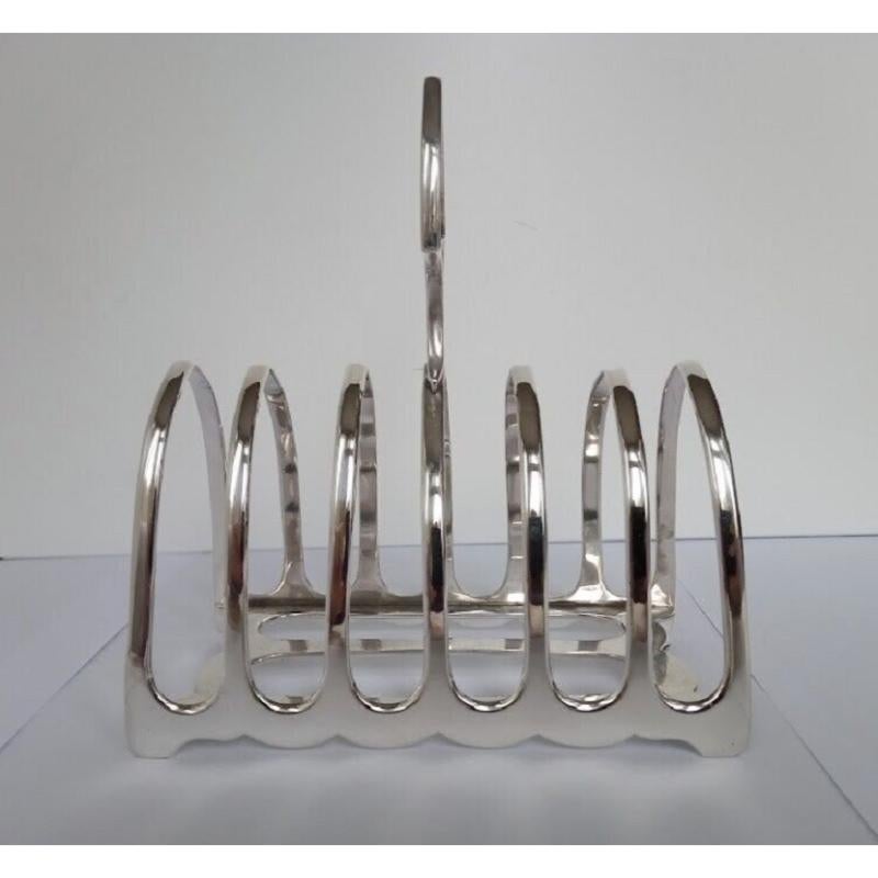 In excellent condition, this is a beautiful Edward VII fine quality, heavy toast rack. It has a rectangular base with rounded ends and scalloped edges. There are high arched dividers, four bracket feet and an oval pointed finger ring handle.  With