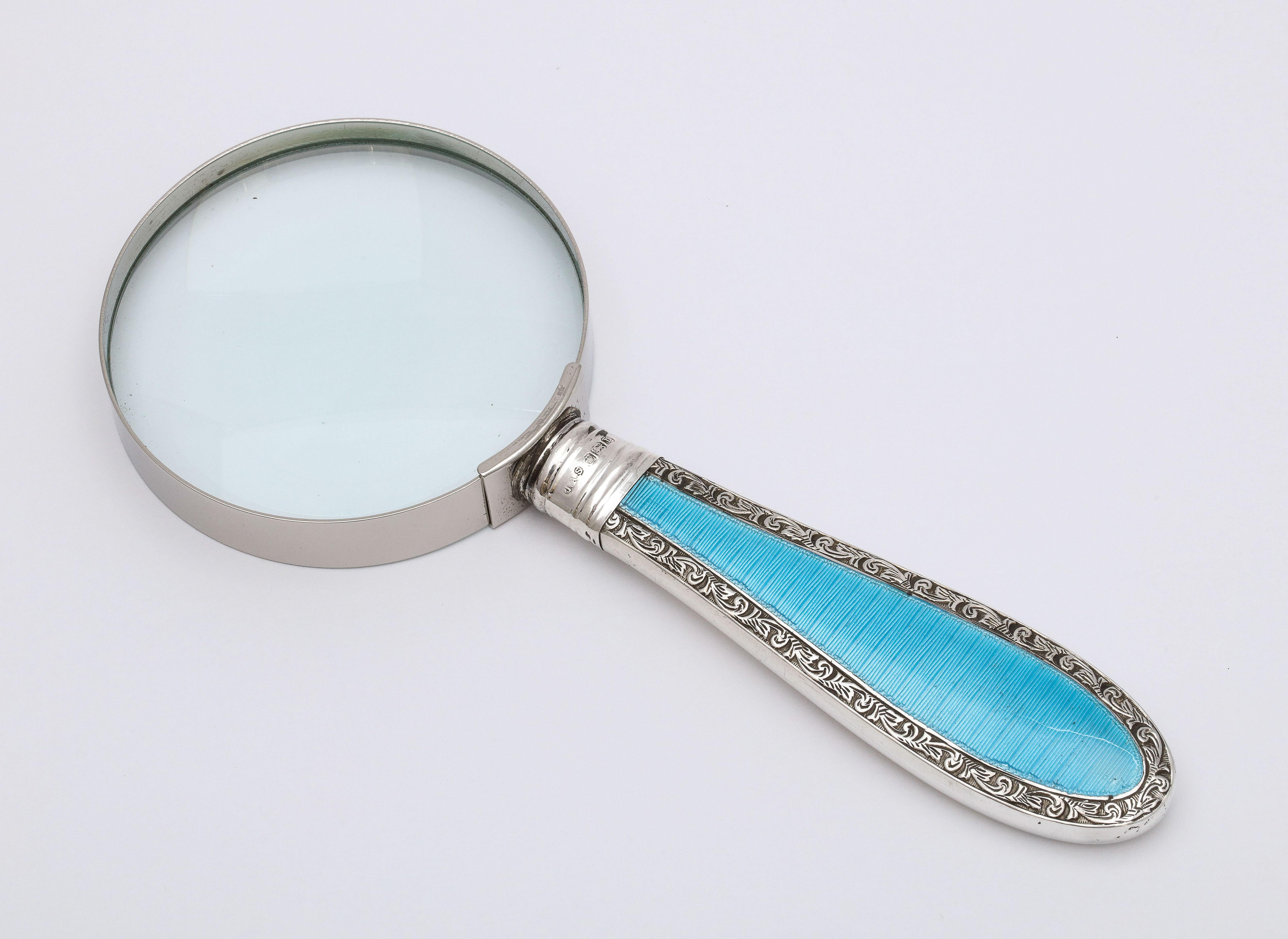 Edwardian, sterling silver and blue guilloche enamel-mounted magnifying glass, Sheffield, England, James Scholes - maker. Measures: 6 inches long x over 2 1/2 inches diameter across glass x 1/2 inches high when lying flat. Enamel is on one side of