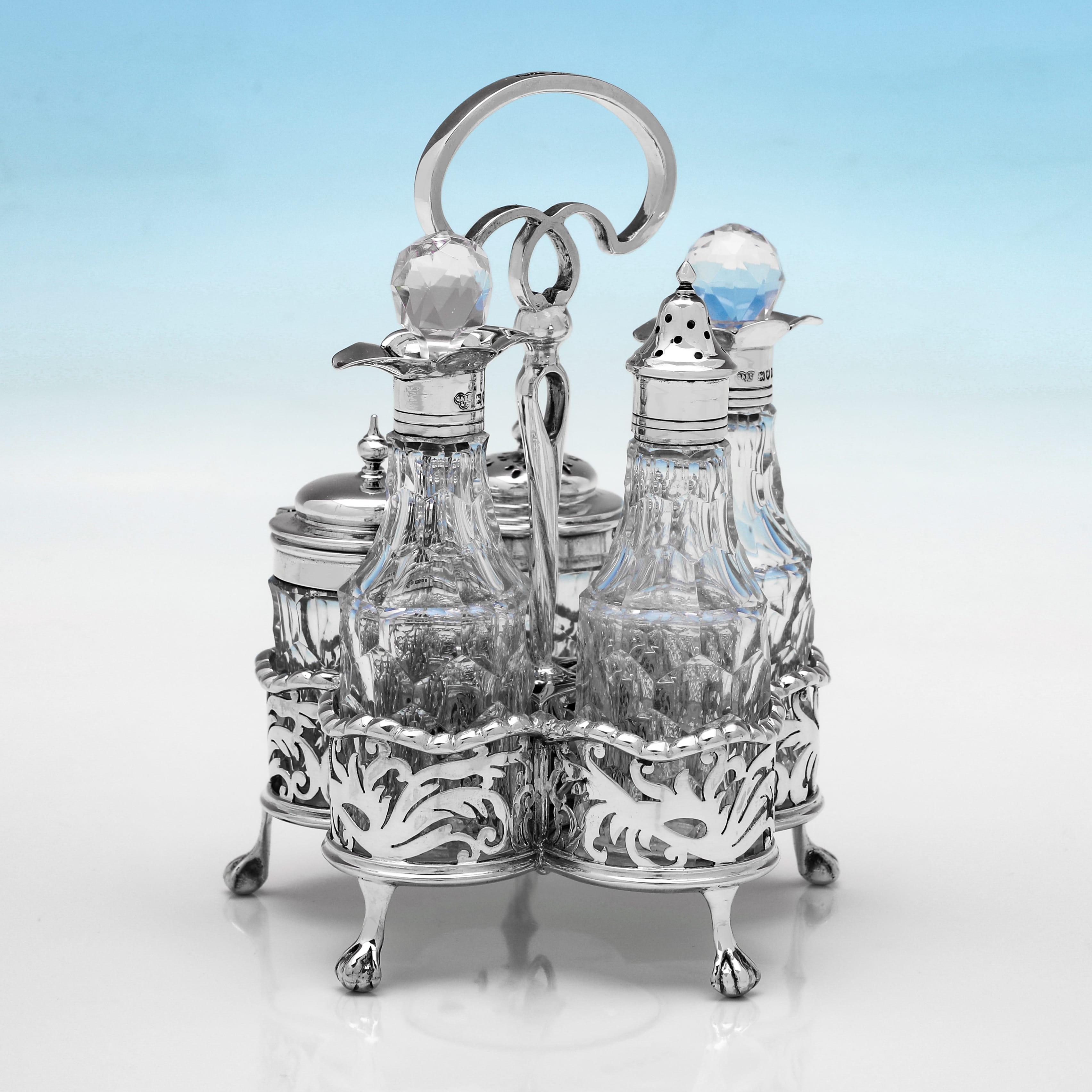 Hallmarked in London in 1908 by Goldsmiths & Silversmiths Co., this elegant, Edwardian, Antique Sterling Silver Cruet Set, comprises 2 oil bottles, a salt, pepper and a mustard pot, all with cut glass bodies and silver mounts with reed detailing.