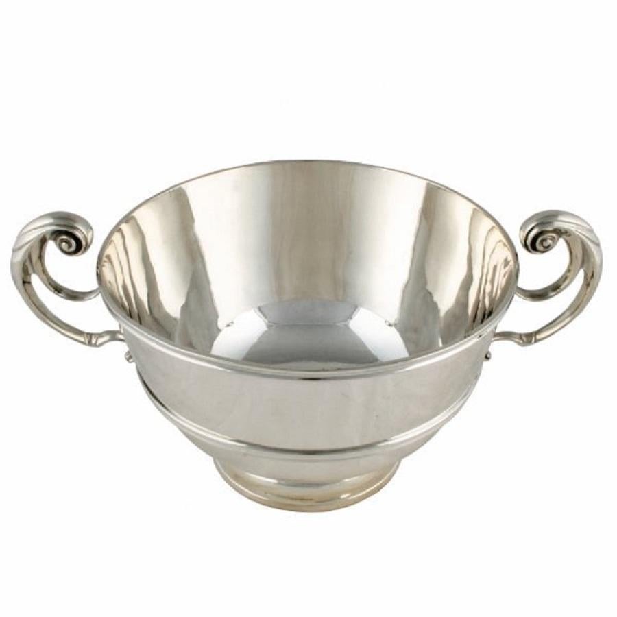 An early 20th century Edwardian sterling silver bowl with two handles.

The bowl has a double rib detail to the rim and half way up the body and a pair of scroll shaped handles decorated on the top edge with a double leaf.

The bowl is hall