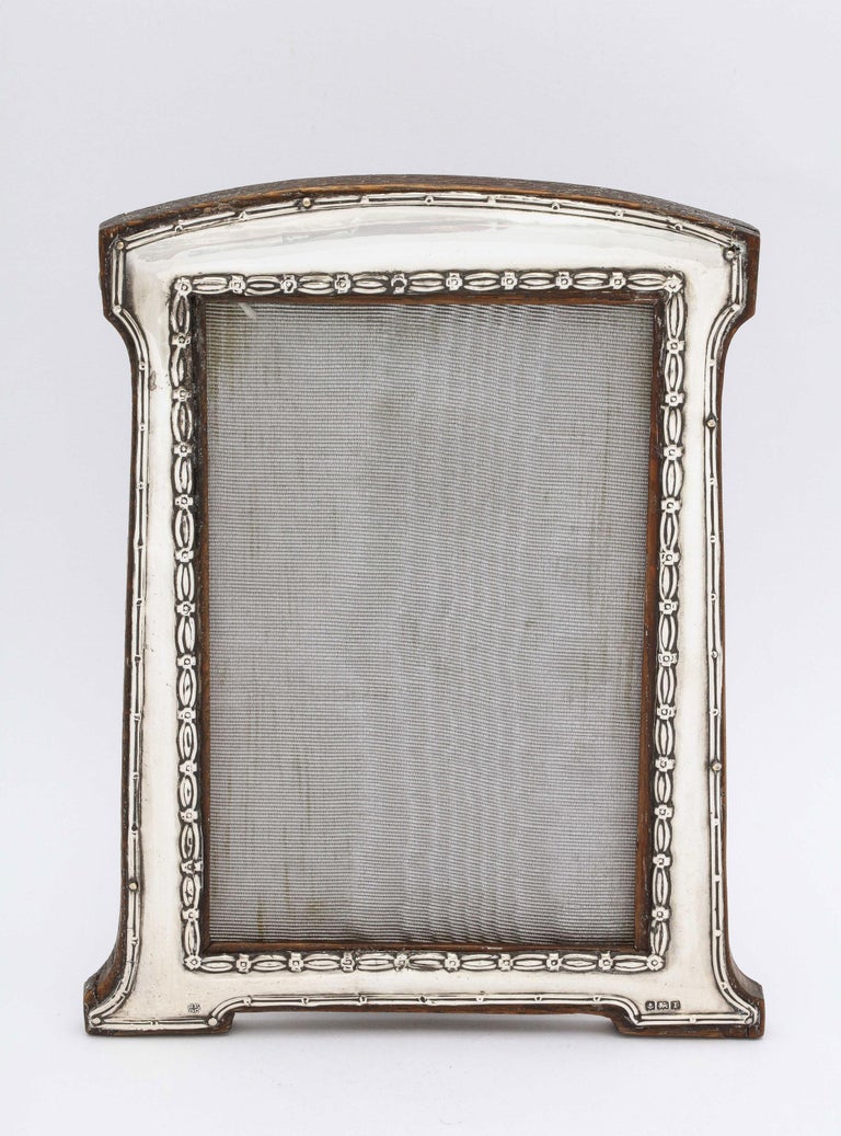 Edwardian, sterling silver, footed picture frame with wood back, Birmingham, England, year-hallmarked for 1910, Boots Pure Drug Company - makers. Measures almost 6 3/4 inches high (at highest point) x 5 1/2 inches wide (at widest point) x 4 1/4 deep