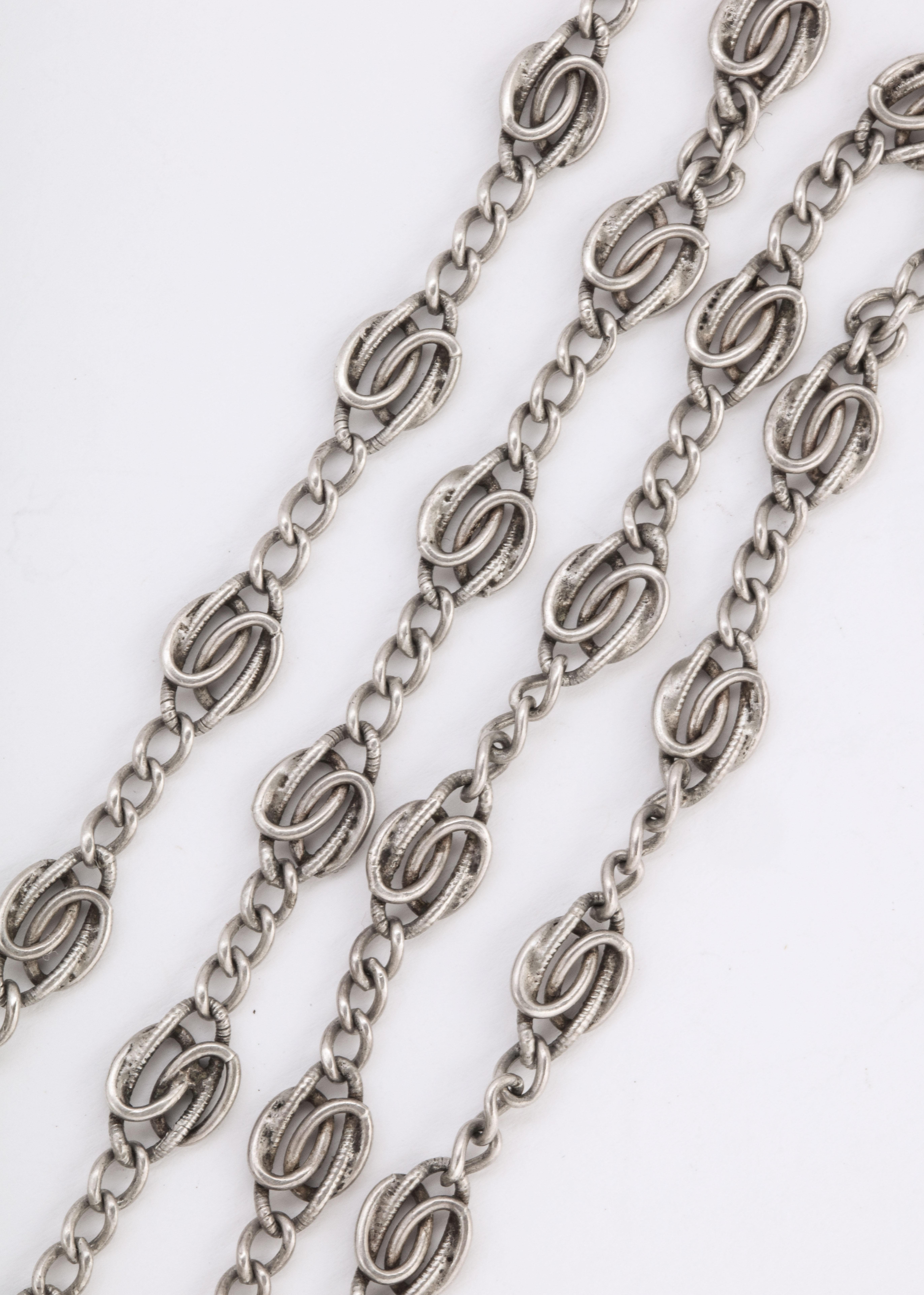Sterling silver chains, such as this Edwardian French Long Chain, are popular because they have patina, texture and can be worn layered with other silver chains. I show a photo of a medium sized locket that can be added to it. This is jewelry that