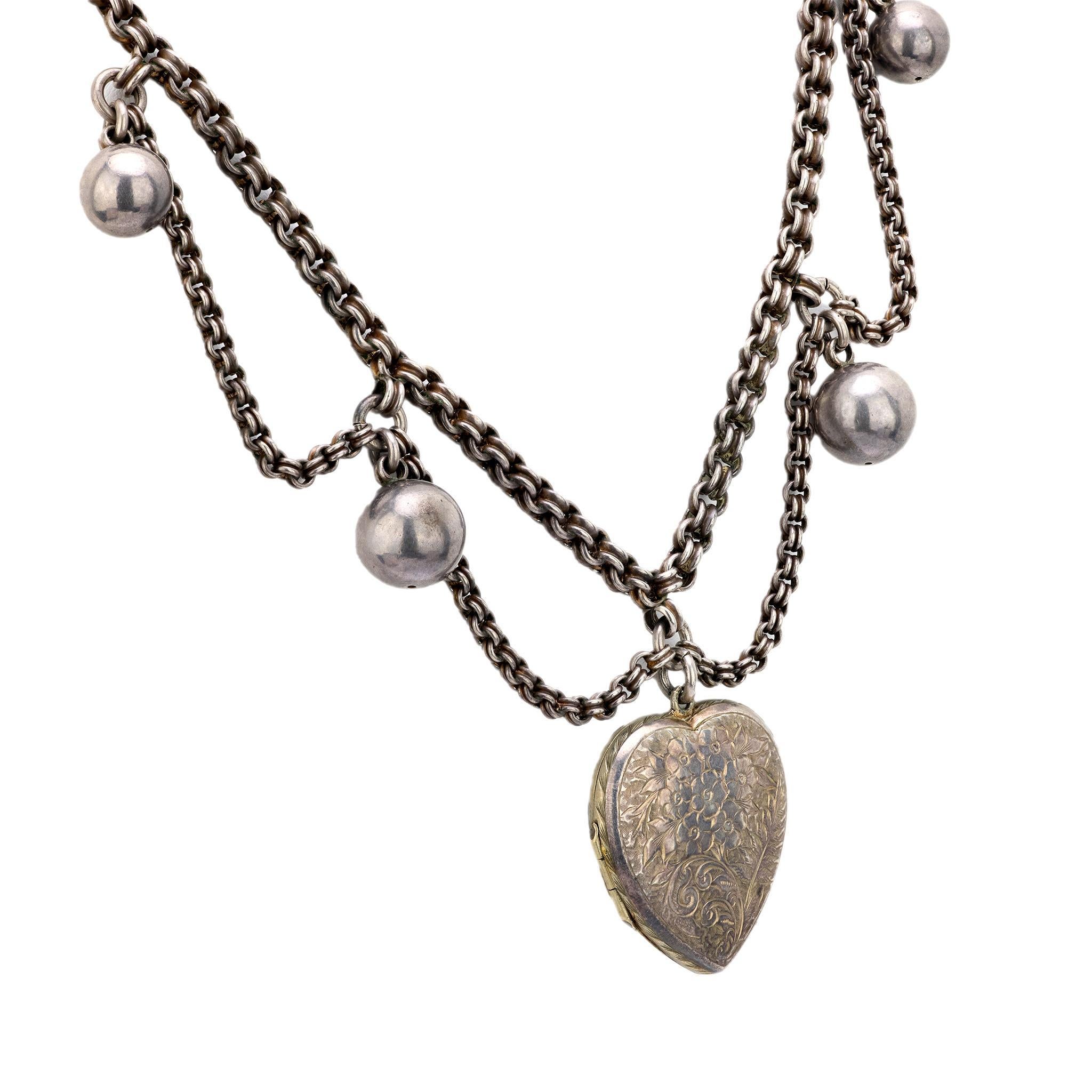 Una favolosa collana con medaglione a cuore di epoca edoardiana (ca. 1910)! Realizzata in argento sterling, questa collana presenta un grande medaglione centrale a forma di cuore. La superficie anteriore e posteriore del medaglione è decorata con