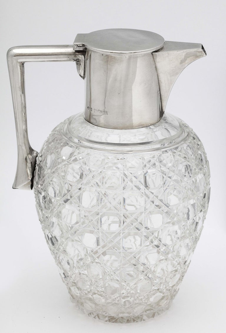Edwardian, sterling silver-mounted, hobnail-cut crystal claret jug, Birmingham, England, 1919, John Grinsell and Sons - makers. Measures 7 3/4 inches high x 4 1/2 inches in diameter (at widest point) x 5 1/4 inches wide from far edge of handle to