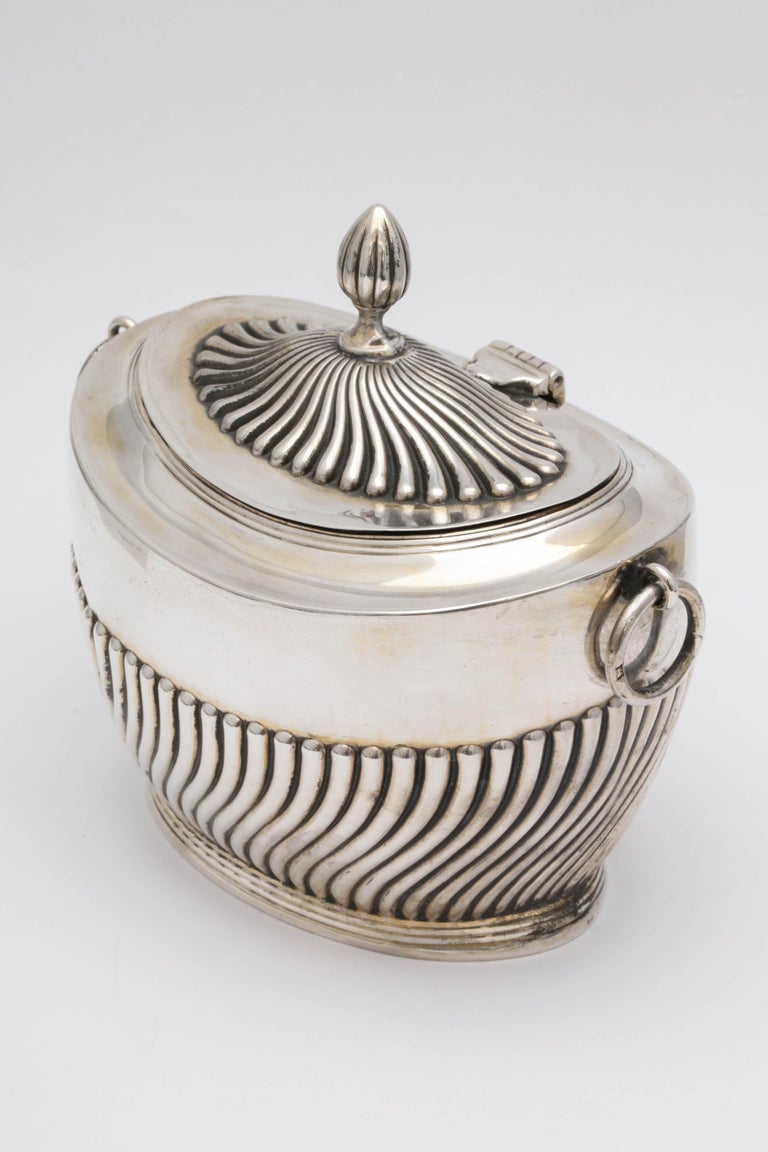 Edwardian, sterling silver, neoclassical style tea caddy with hinged lid, London, 1907, Robert Pringle - maker. Lovely fluted design; handles are rings. Measures: Almost 4 1/2 inches high (to top of finial) x 4 1/2 inches wide (from ring to ring) x