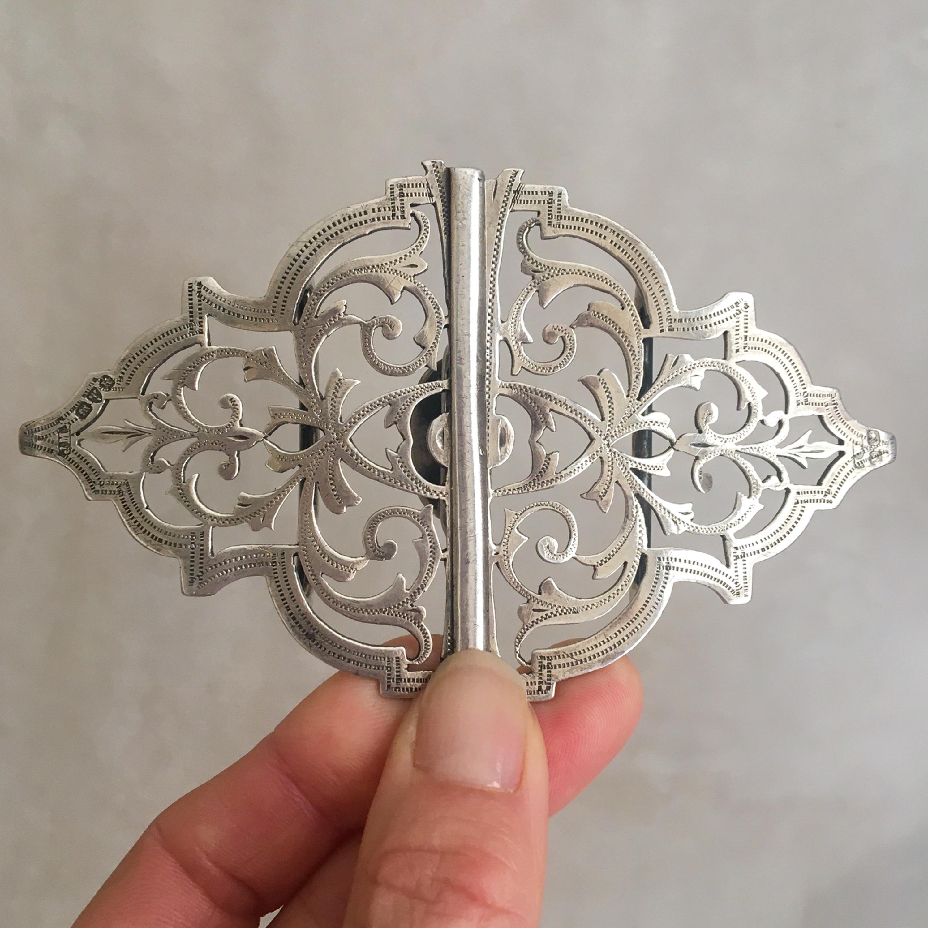 This is an antique Edwardian nurses belt buckle crafted in sterling silver. An excellent slightly curved shape buckle, decorated with pierced work pattern and engraved foliage. Popular motifs in this Edwardian artisan era includes, flowers,