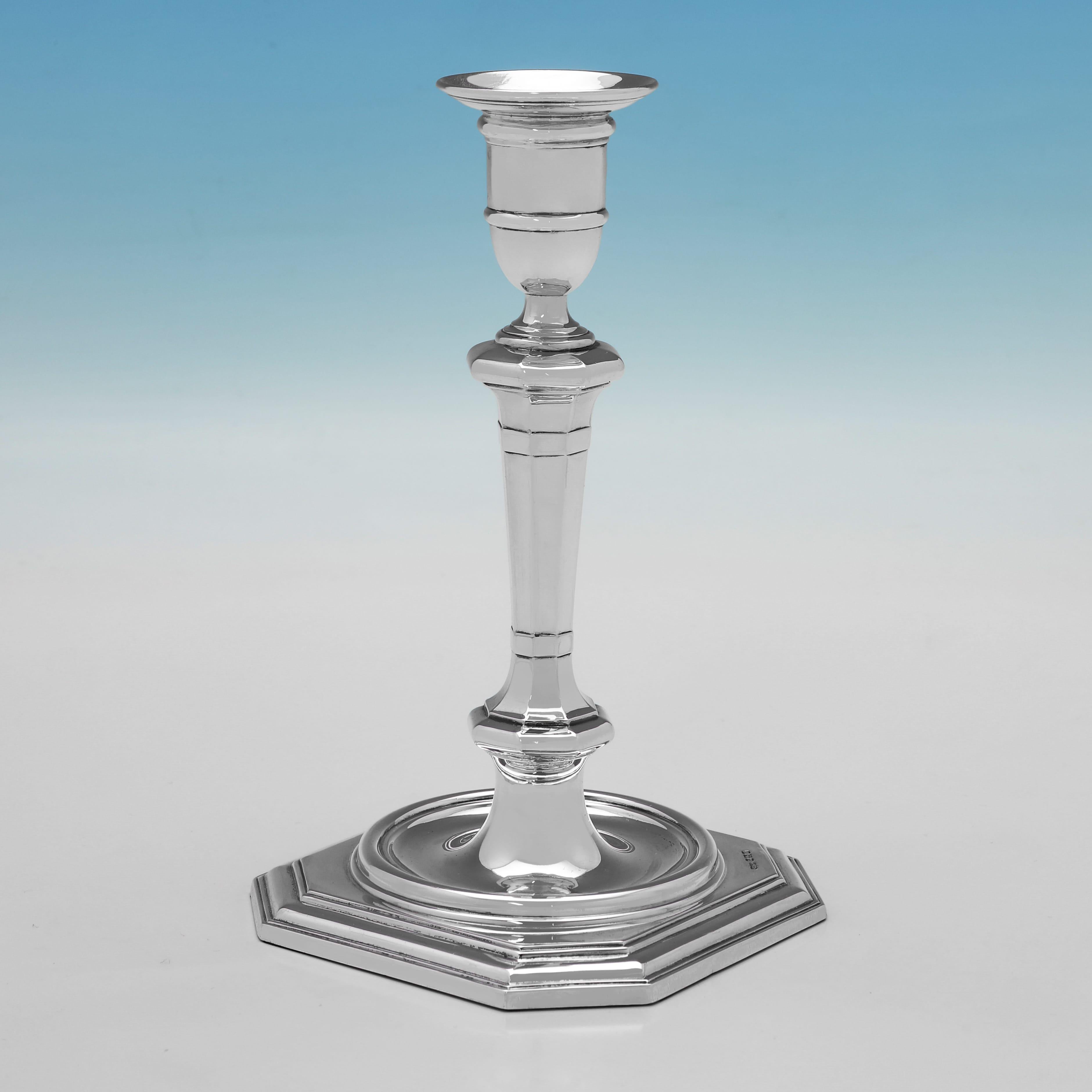 Hallmarked in Sheffield in 1906 by James Dixon & Sons, this handsome pair of Antique, Edwardian Sterling Silver Candlesticks, are plain in design, with reed detailing, octagonal bases, and removable nozzles. Each candlestick measures 8