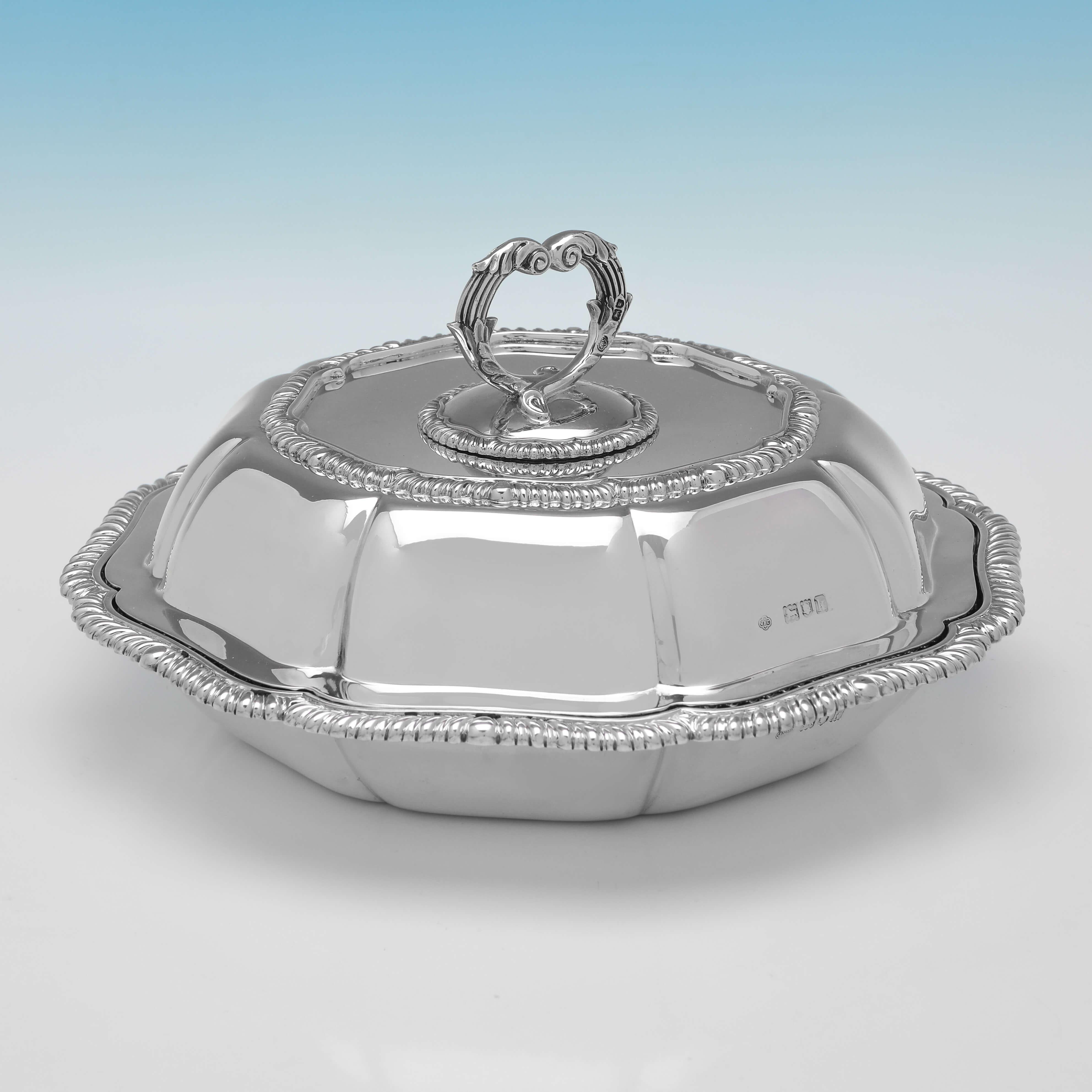 Hallmarked in London in 1905 by Carrington & Co., this charming pair of Edwardian, Antique Sterling Silver Entree Dishes, are octagonal in shape, and feature gadroon borders and removable handles. 

Each entree dish measures 3.75