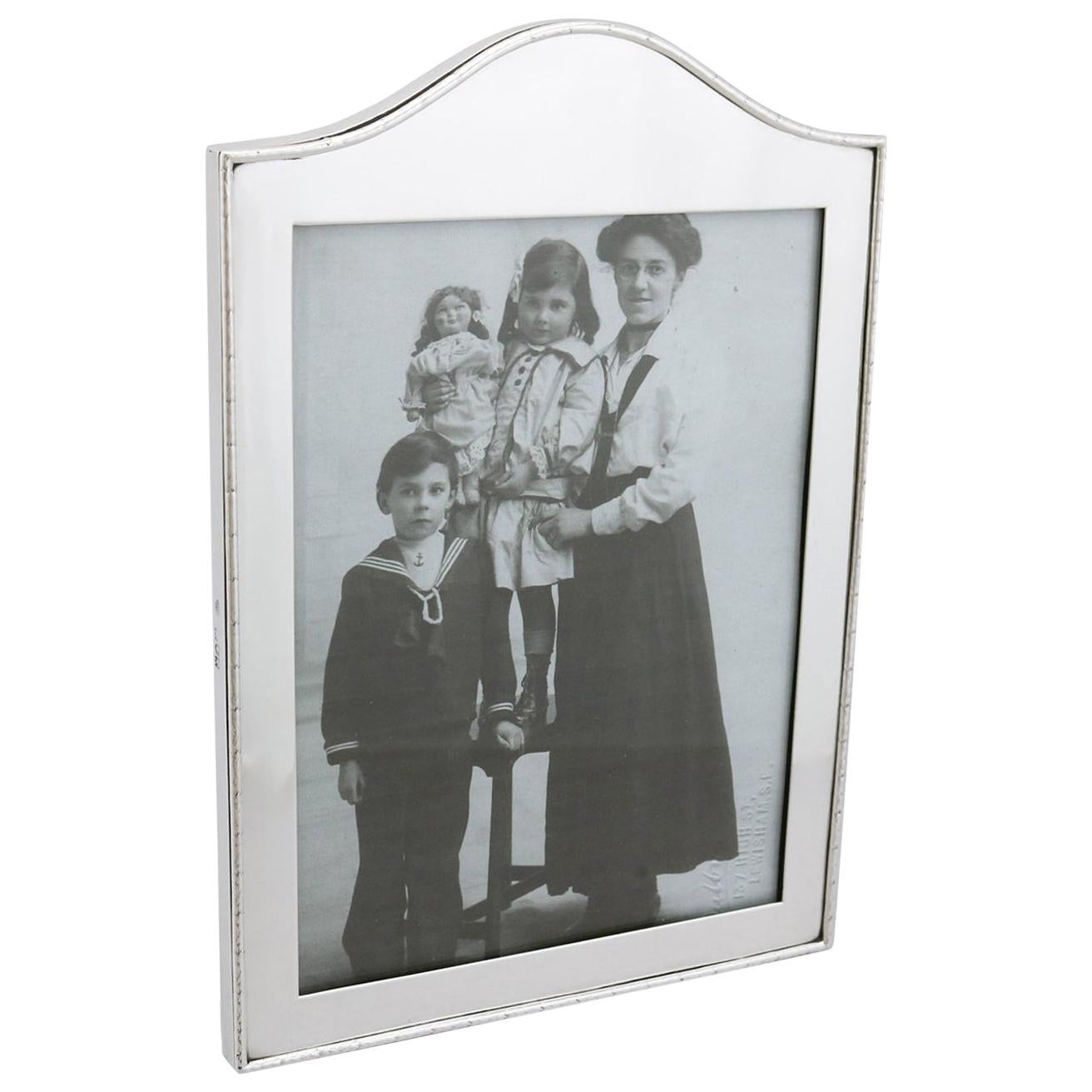 An exceptional, fine and impressive antique Edwardian English sterling silver photograph frame; an addition to our ornamental silverware collection.

This exceptional antique Edwardian sterling silver photograph frame has a rectangular shaped form