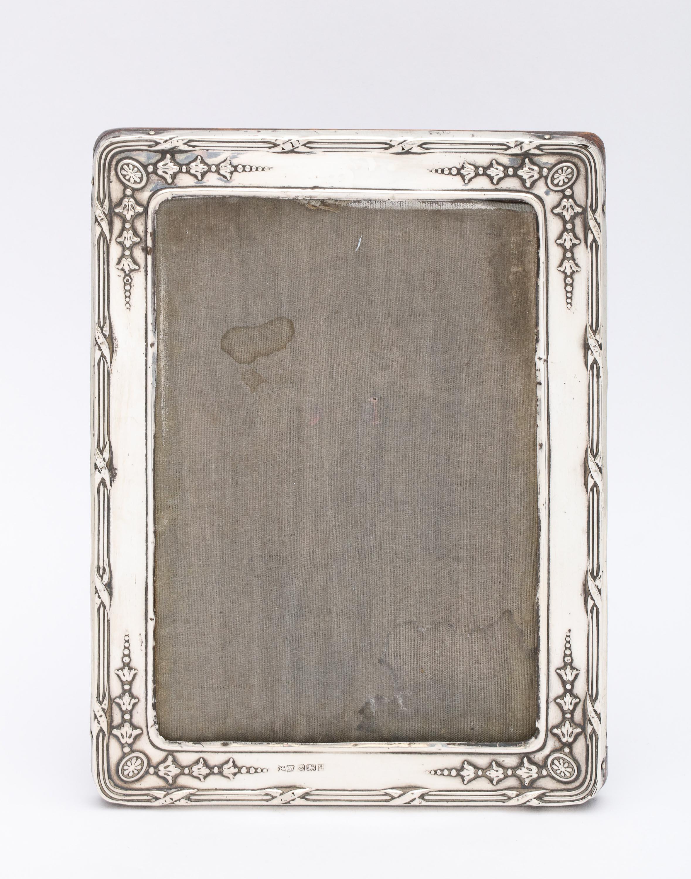 Edwardian, sterling silver picture frame with wood back, Birmingham, England, year-hallmarked for 1915, H. Matthews - maker. Measures 6 3/4 inches high x 5 inches wide x 4 1/2 inches deep (when easel is in open position). Will hold a photo that is 5