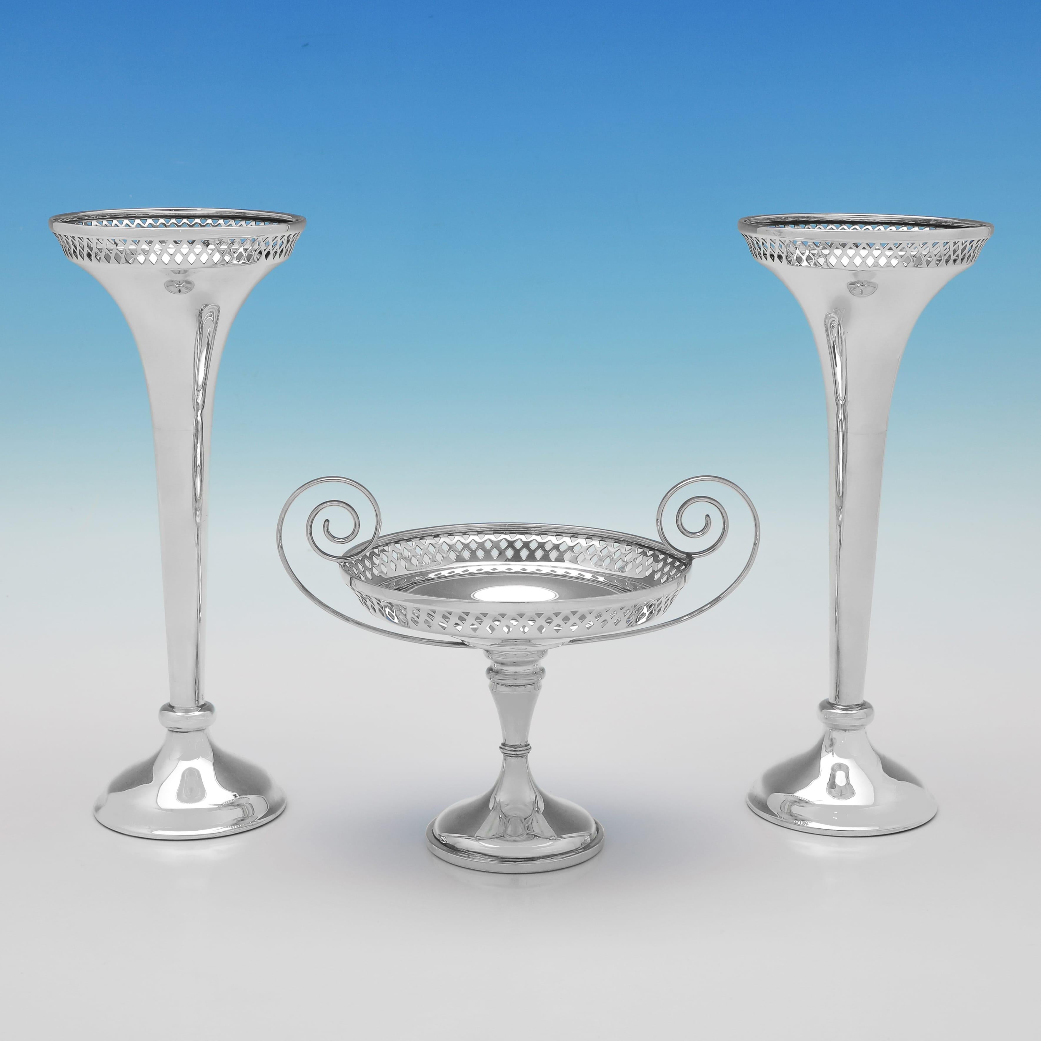 Marchiata a Sheffield nel 1909 da Walker & Hall, questa incantevole suite in argento sterling antico, composta da una coppia di vasi e una tazza, presenta decorazioni traforate intorno ai bordi e viene presentata nella sua scatola originale.
 
 Ogni