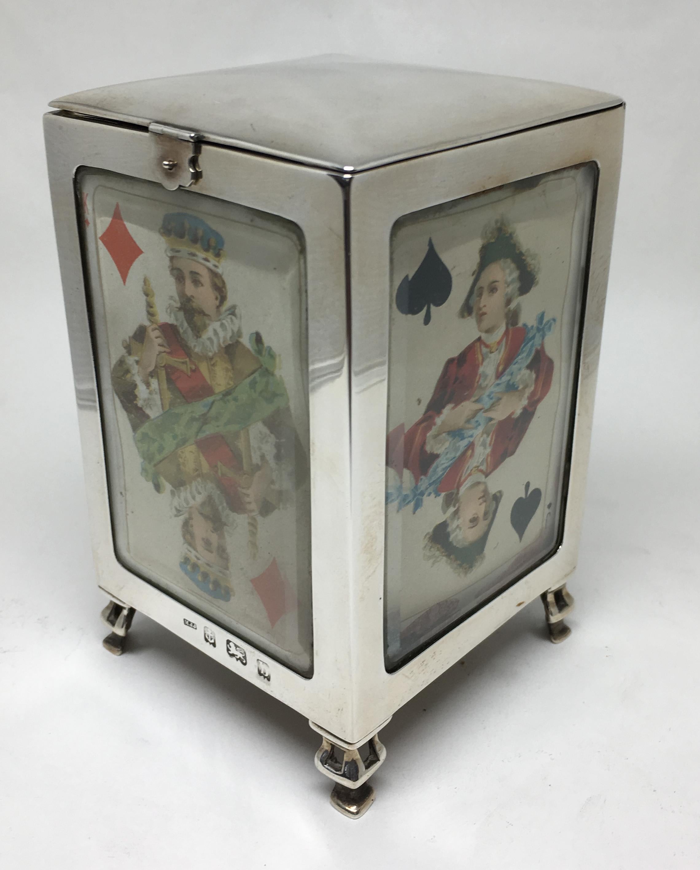 A rare and unusual Edwardian sterling silver upright standing playing card box for 3 packs of cards.

Hallmarked for Birmingham 1901.

Each face with bevelled glass and original playing card, the box on four decorative feet. With a simple clasp