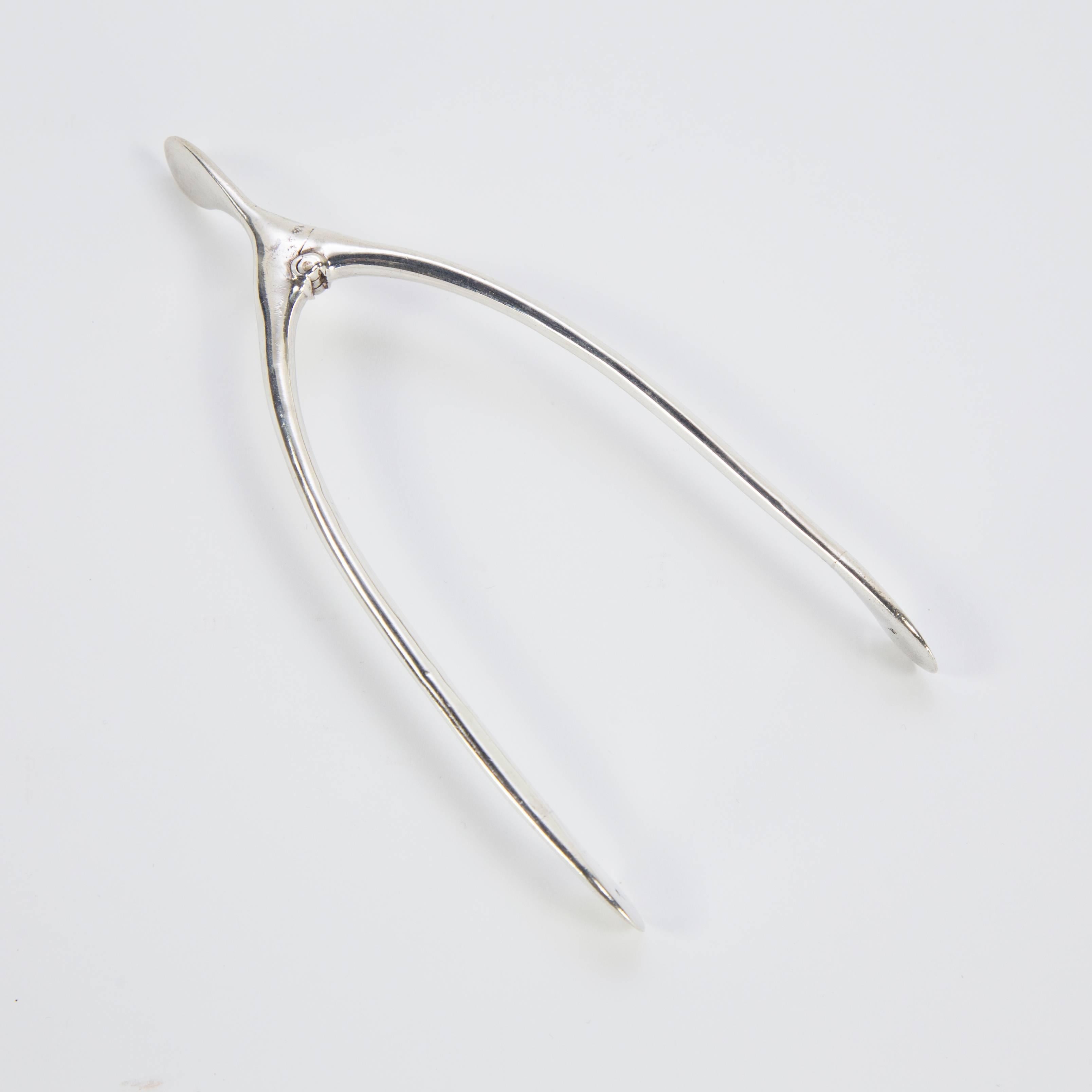 Pair of sterling silver sugar cube tongs in the shape of a wishbone! Fully hallmarked with Birmingham hallmark, letter date corresponds to 1907. Tongs measure approximate 5.5
