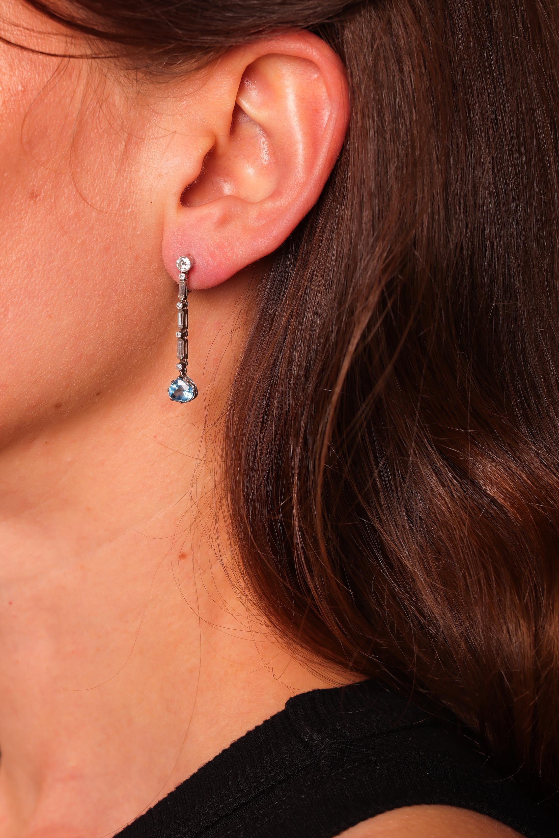 Pietra centrale: 2 acquamarine
Taglio: Taglio a pera
Peso: 1,27 carati
Colore: blu
A. Stone: 10 diamanti 
Taglio: Taglio rotondo brillante
Peso: Circa .50 Carati
Colore: I
Chiarezza: You Si
Accent Stone: 6 diamanti
Taglio: Taglio Baguette
Peso: