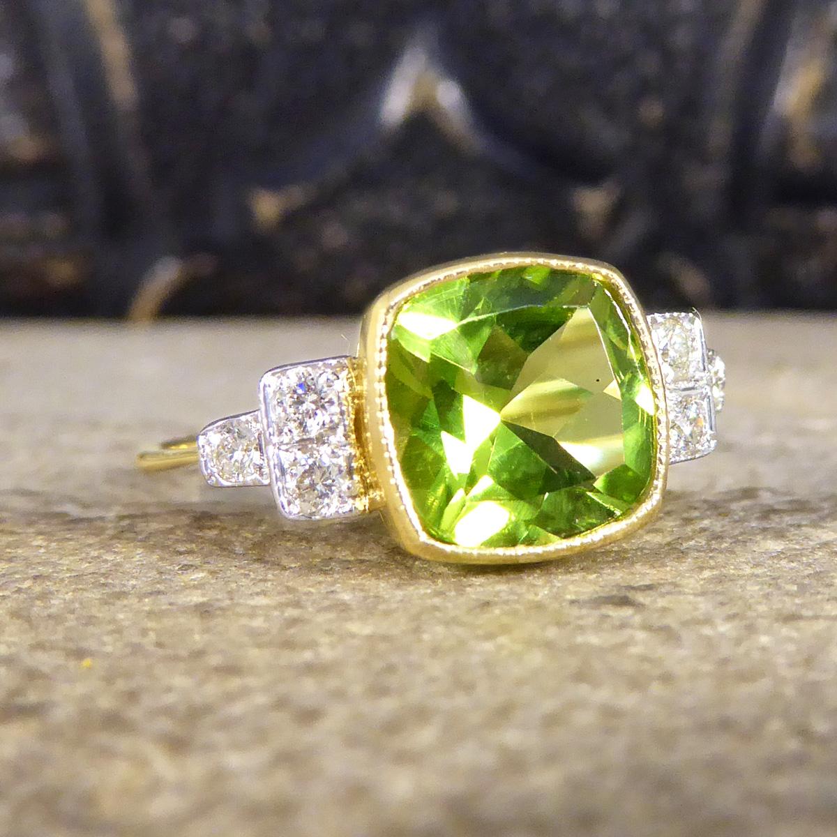 This absolutely stunning ring features a bright and vibrant Peridot in the centre weighing 2.12ct set in a collar setting with a slight milgrain edge. Sitting on either shoulder of the ring are a triangle of brilliant cut Diamonds, set in a