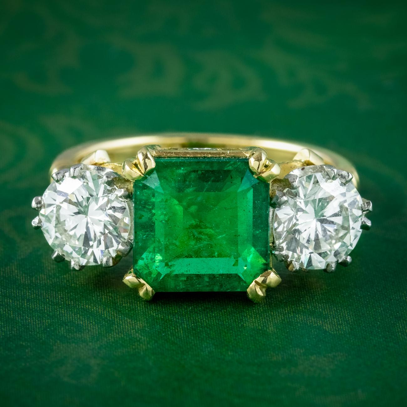 A magnificent Edwardian inspired trilogy ring boasting a gorgeous square step cut emerald in the centre with a vibrant, grassy green hue. It’s accompanied by an E.D.R gem certification which verifies it’s natural and weighs an estimated 3.39