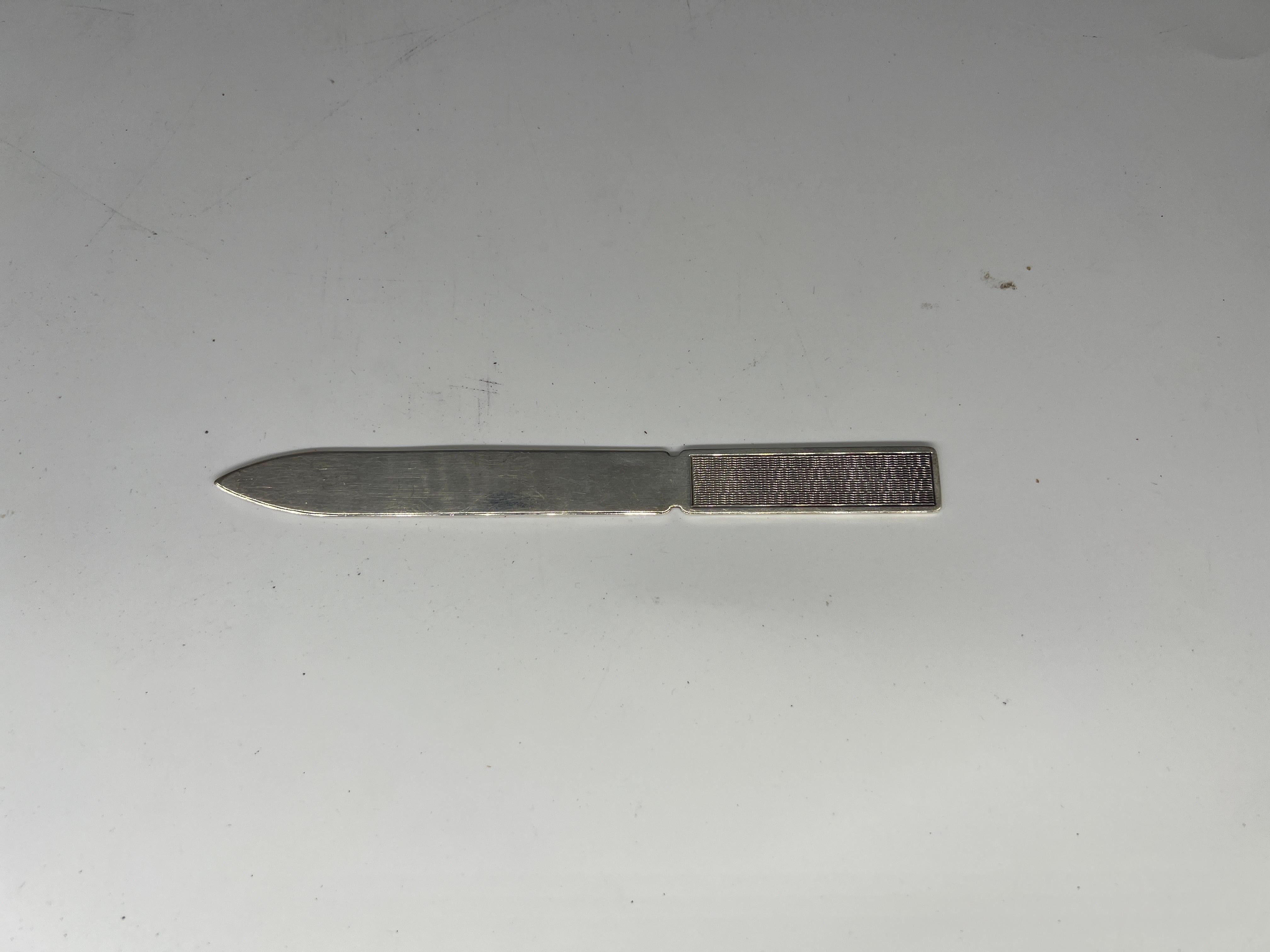 Ari D Norman (English, L. 20th / E. 21st Century), circa 2004. 

A beautiful sterling silver letter opener with an engine turned handle and fully hallmarked to the blade. 