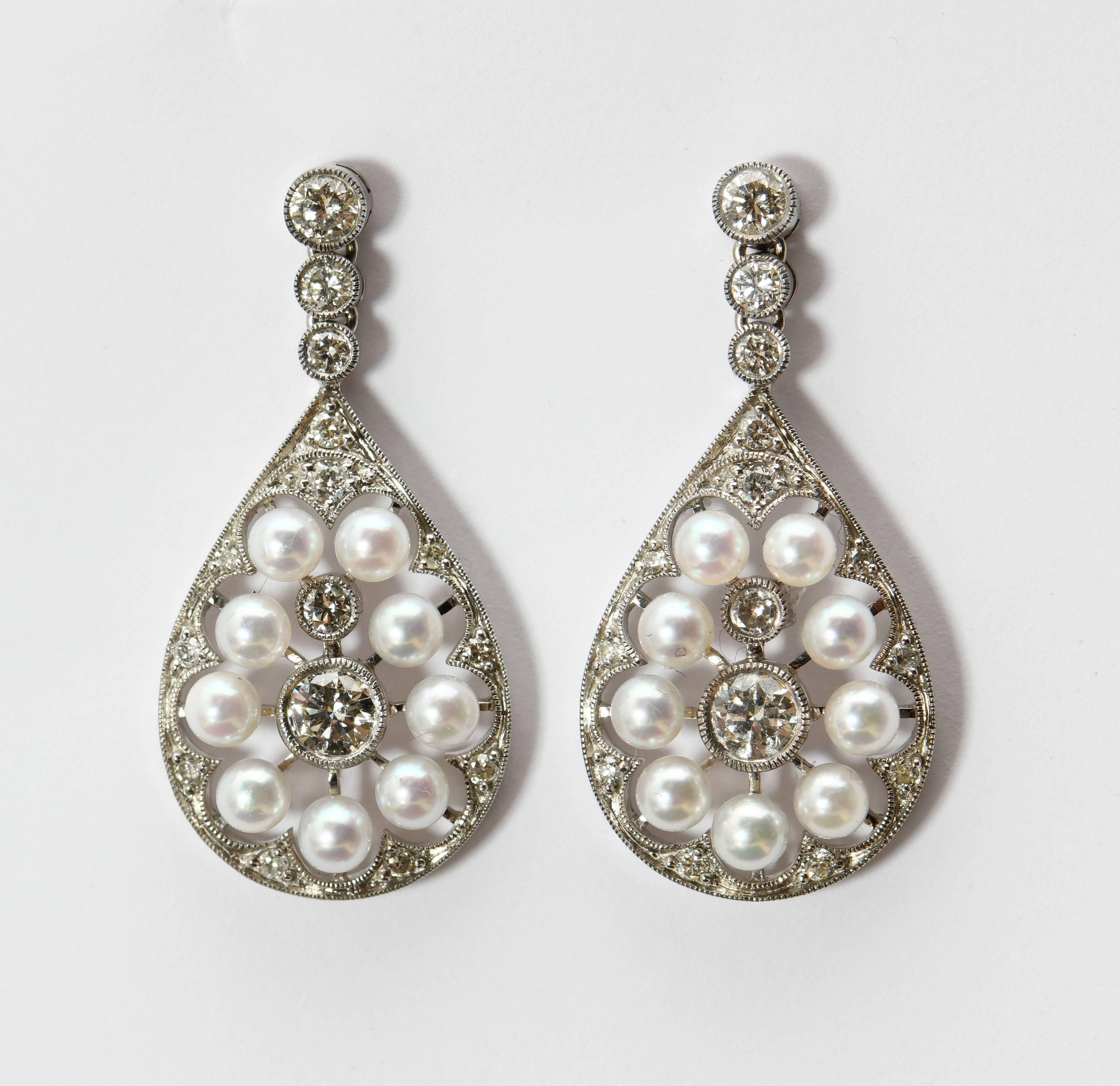 These are earrings of elegant, understated beauty. The Edwardian design is in a classic water drop shape suspended below three diamonds. The pearls set on bars radiating from the central diamond are reminiscent of a snowflake. The borders and the